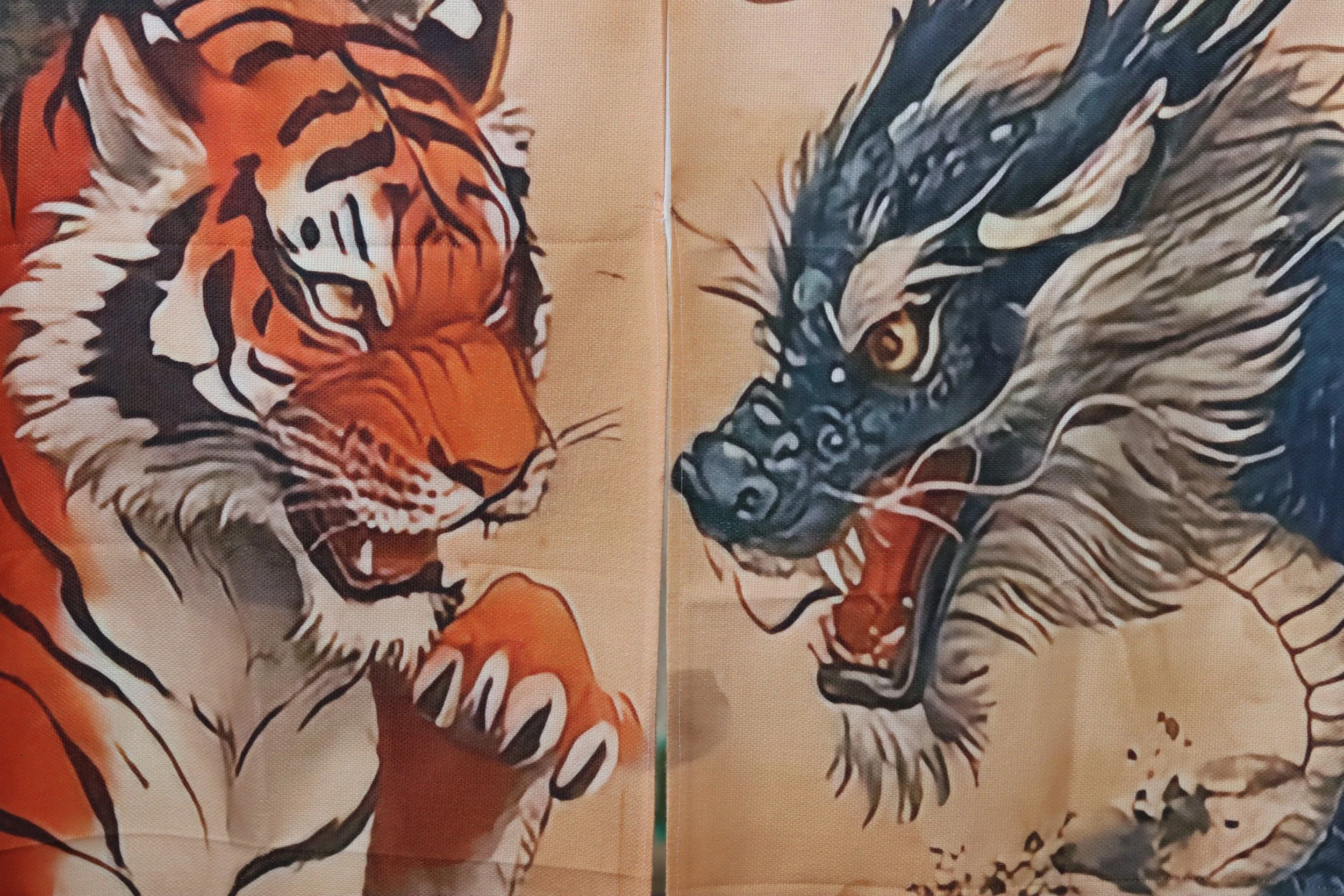 Ein Bild von zwei handbemalten Stofftüchern mit Tiermotiven, einem Löwen auf der linken Seite und einem Löwenkopf auf der rechten Seite.