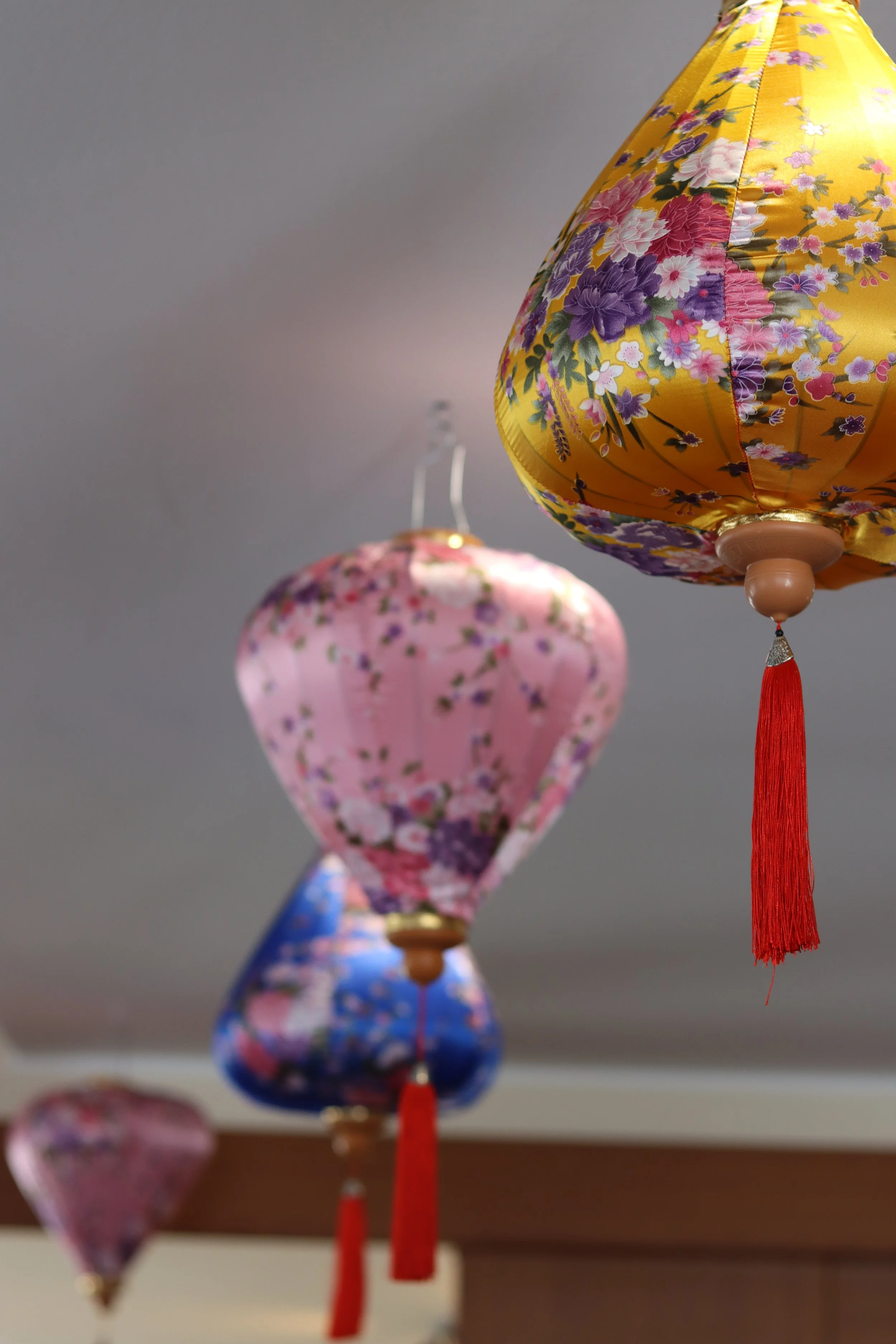 Bunte, mit Blumenmuster verzierte Laternen hängen von der Decke.