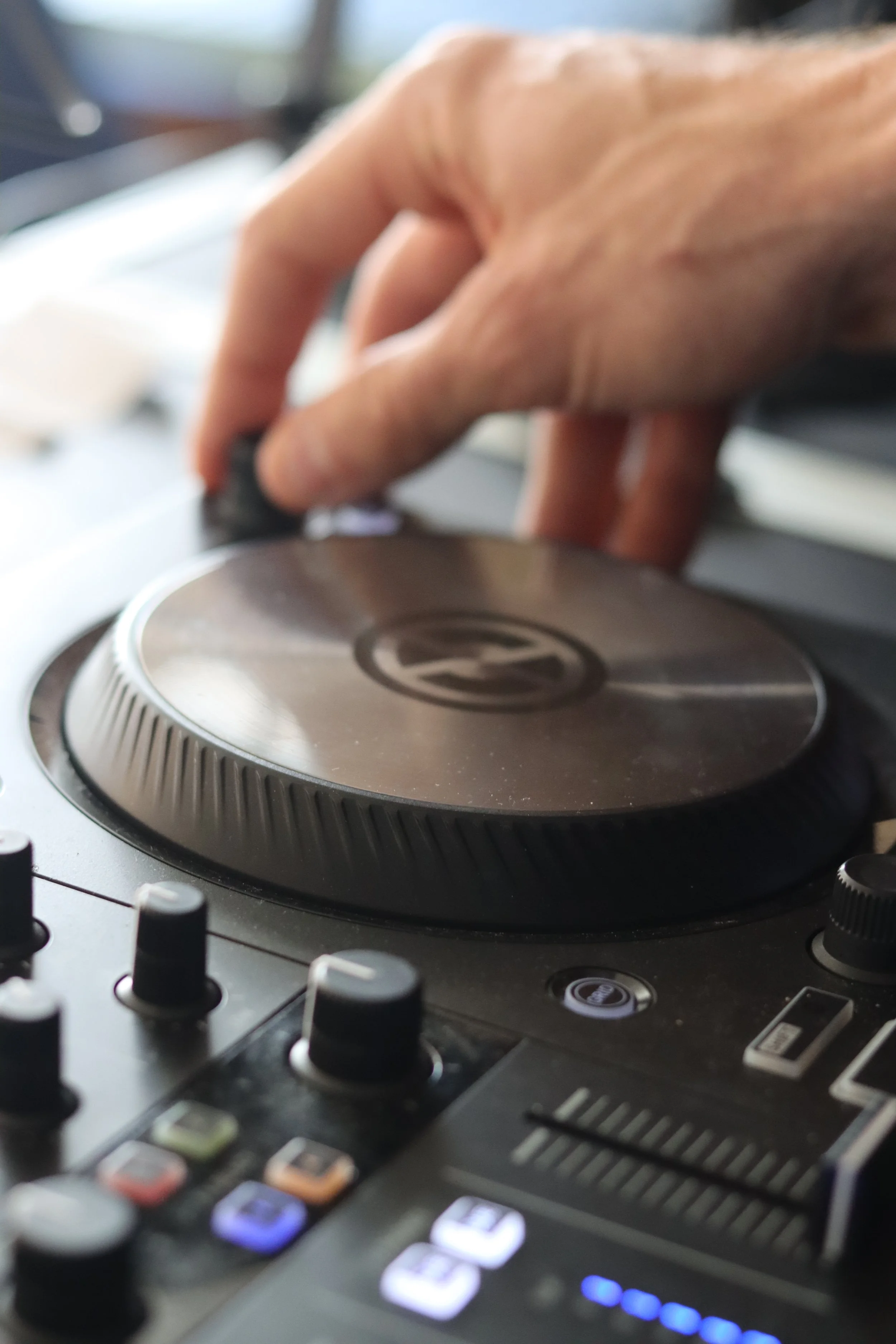 Nahaufnahme eines DJ-Mixers mit Hand, die den Plattenteller bedient