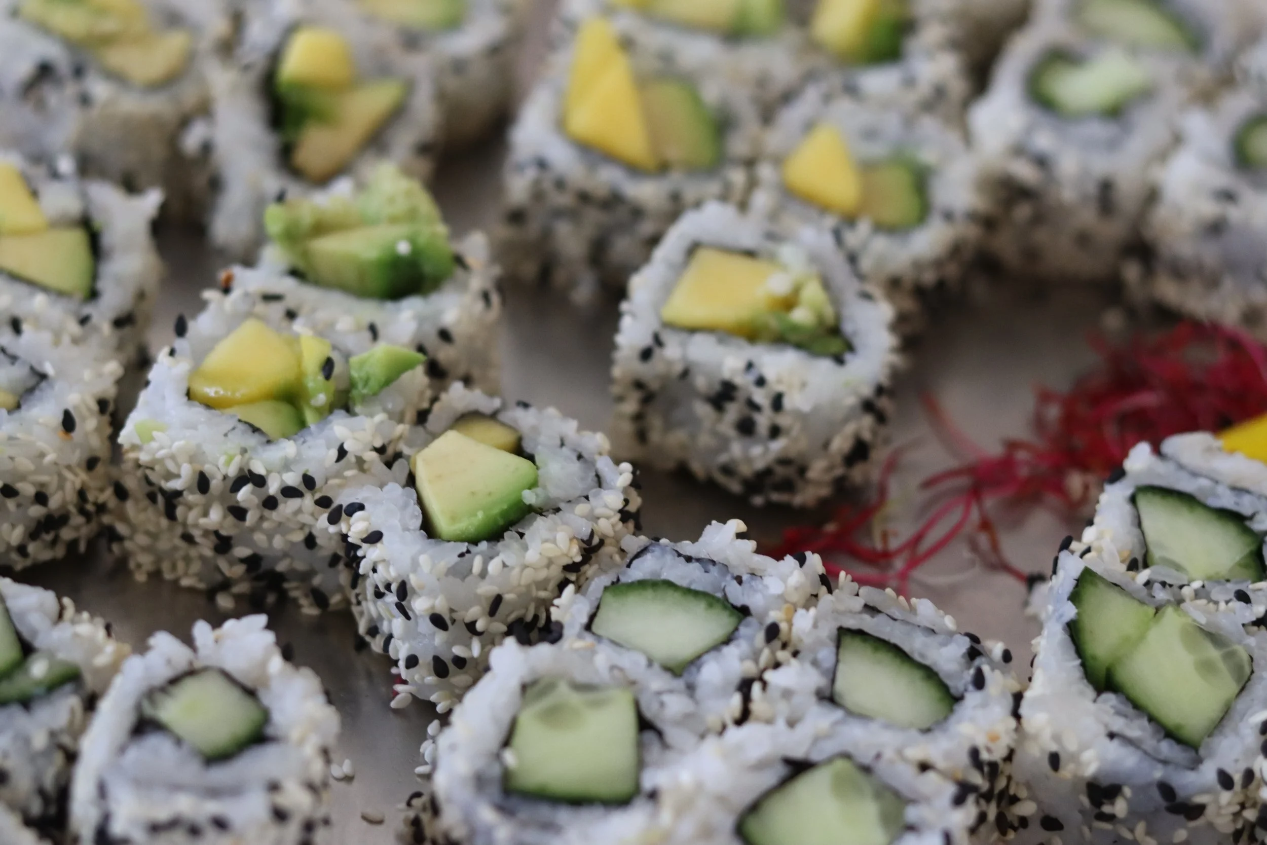 Sushi mit Avocado, Sesamsamen und frischem Gemüse.