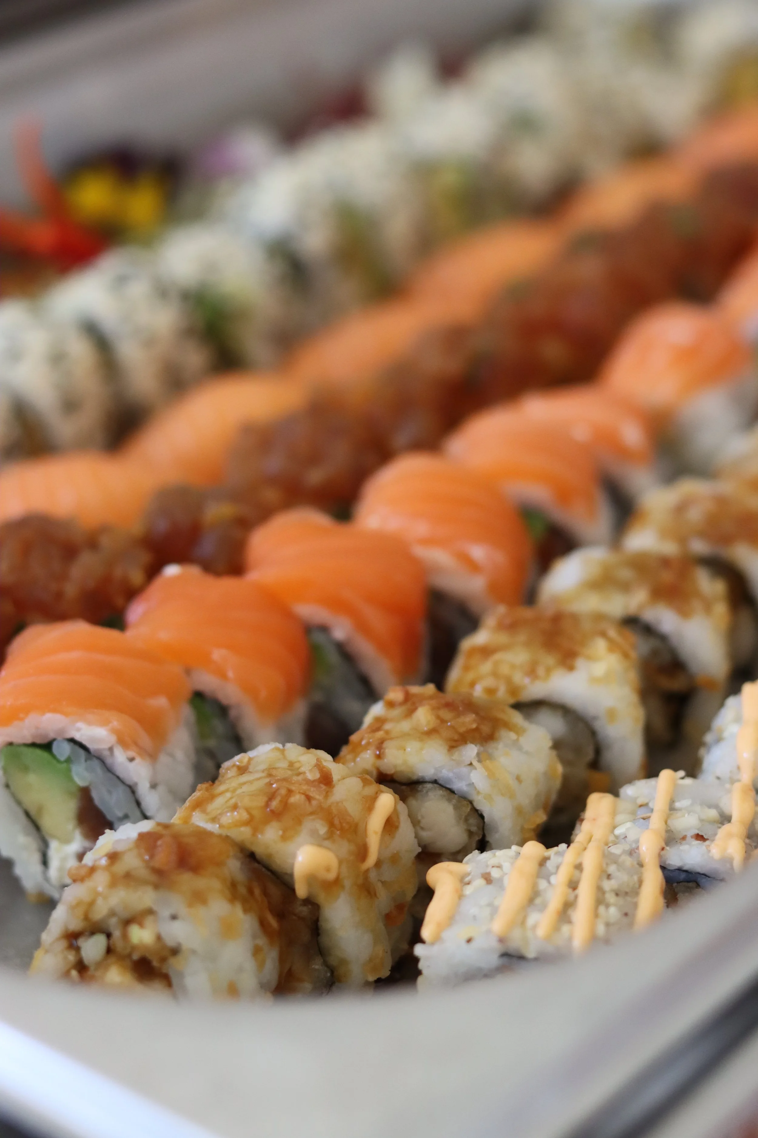 Nahaufnahme verschiedener Sushi-Rezepte auf einem weißen Teller.