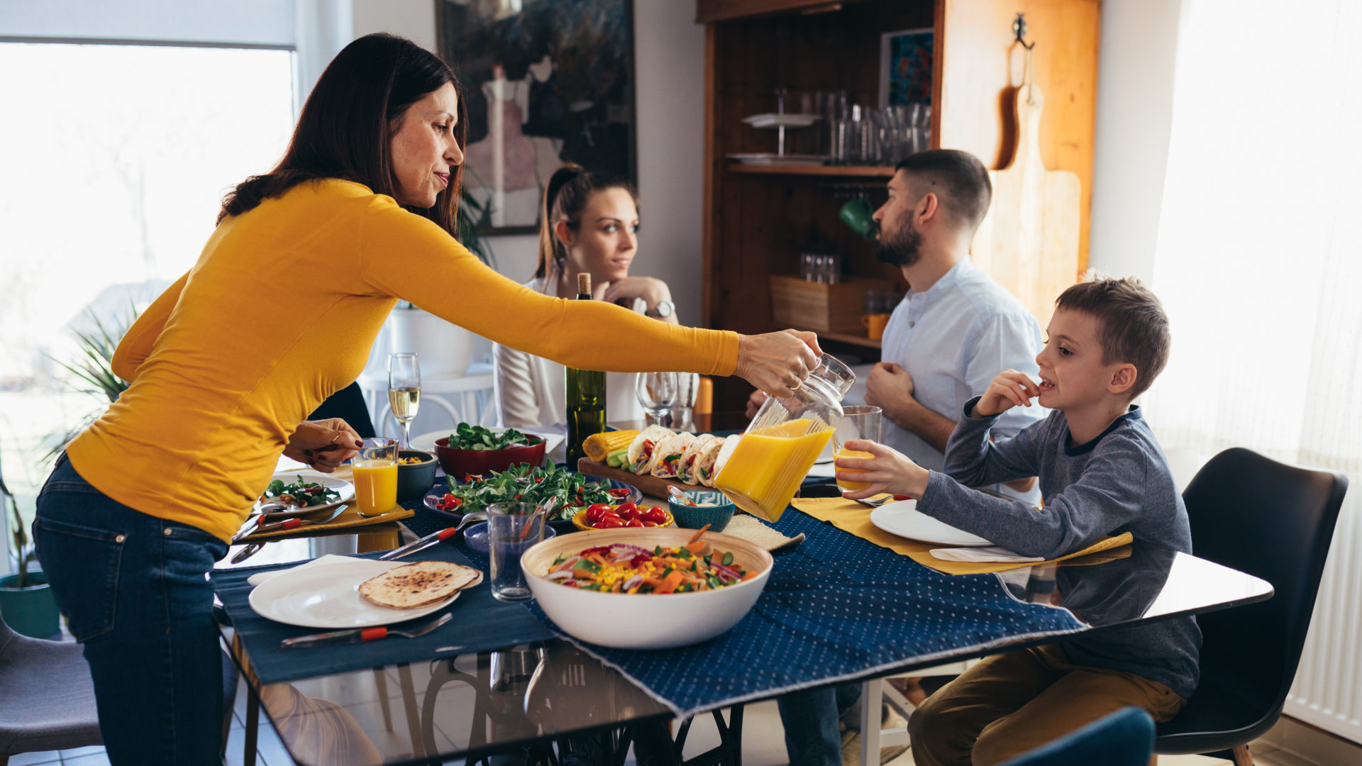 A family sitting around a table at mealtime.