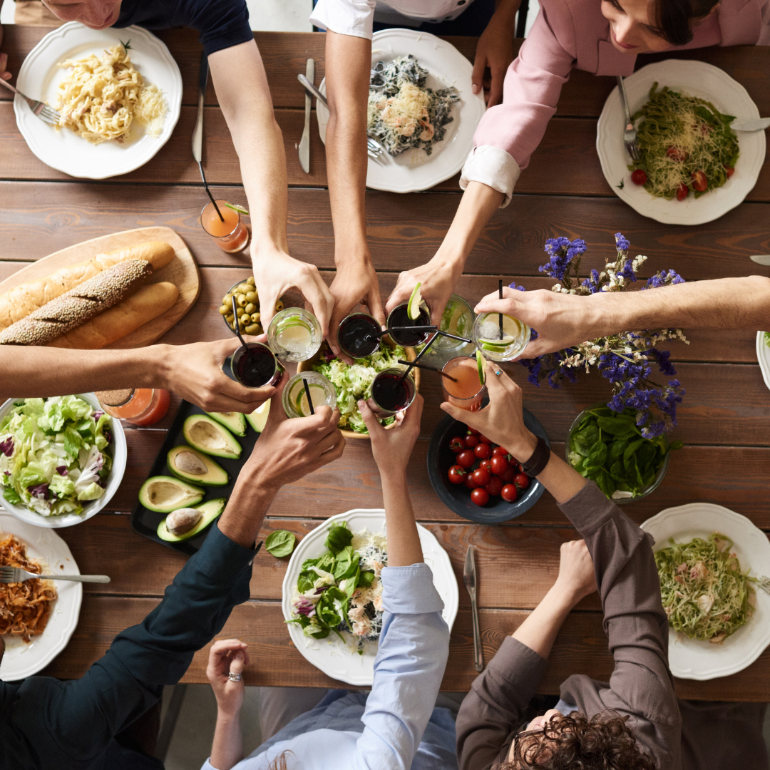 a group of people sharing a meal over a large dining table.