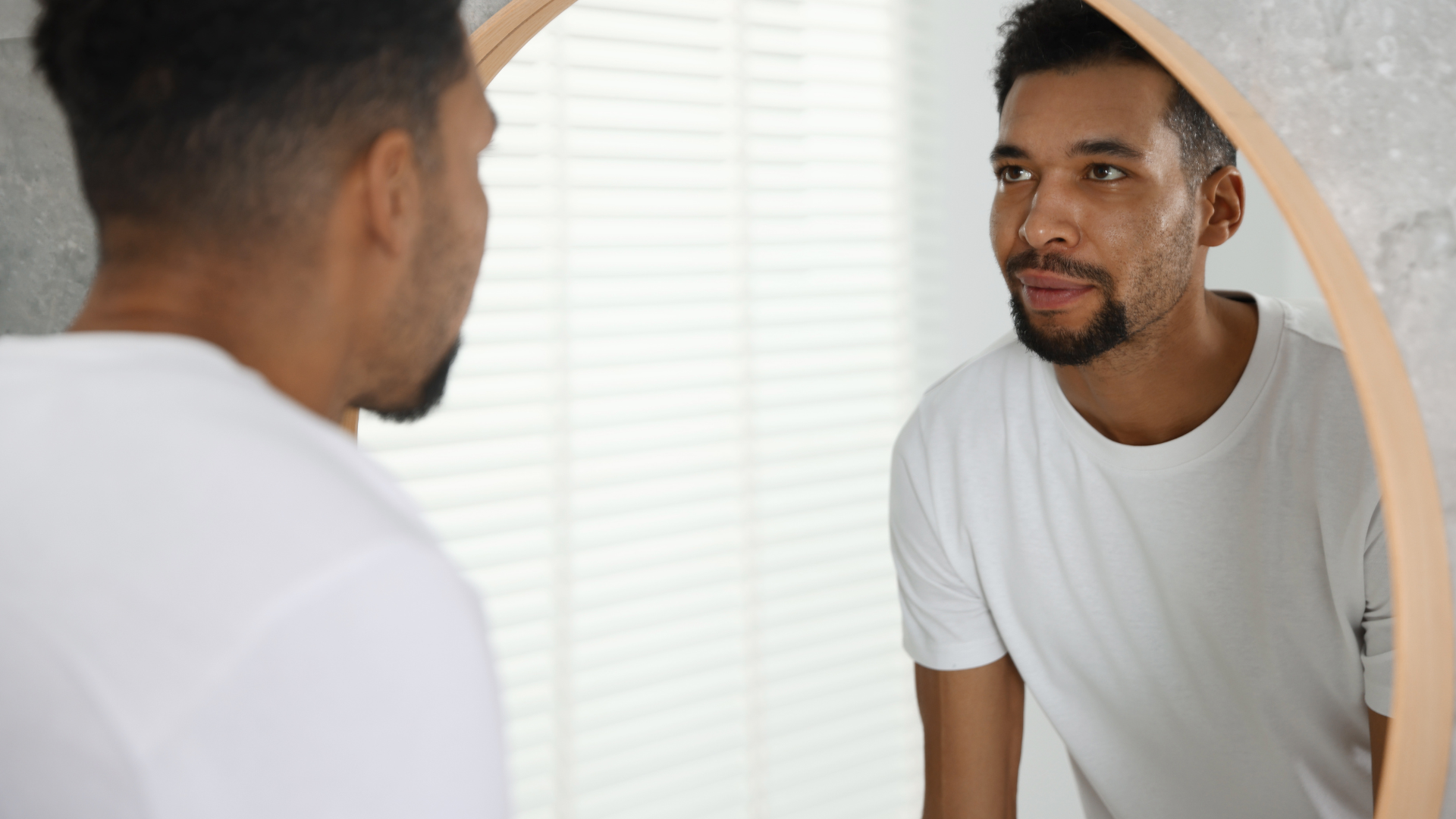 A man looking at himself in a mirror.