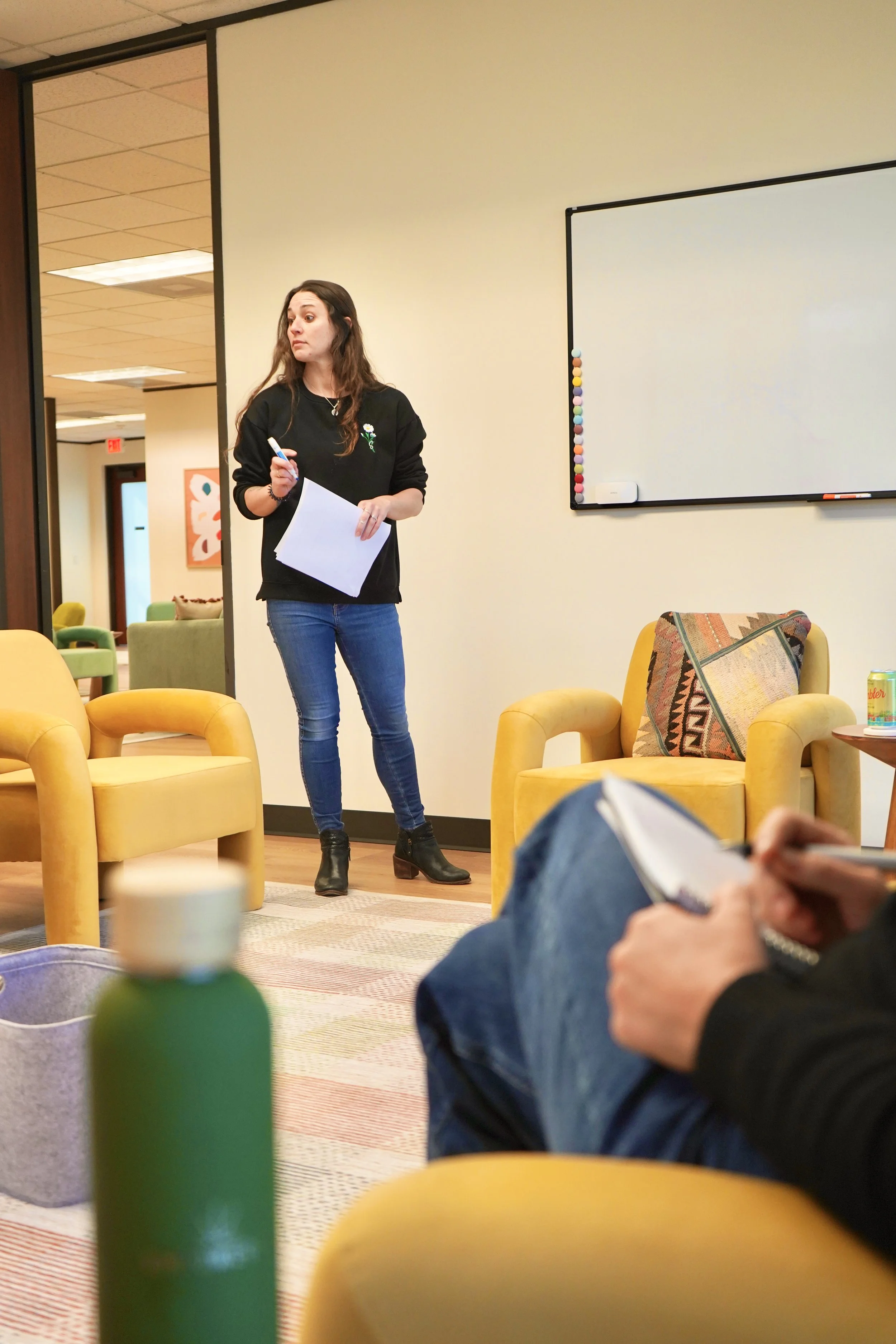 a therapist at our outpatient program leading a group in a bright, colorful room.