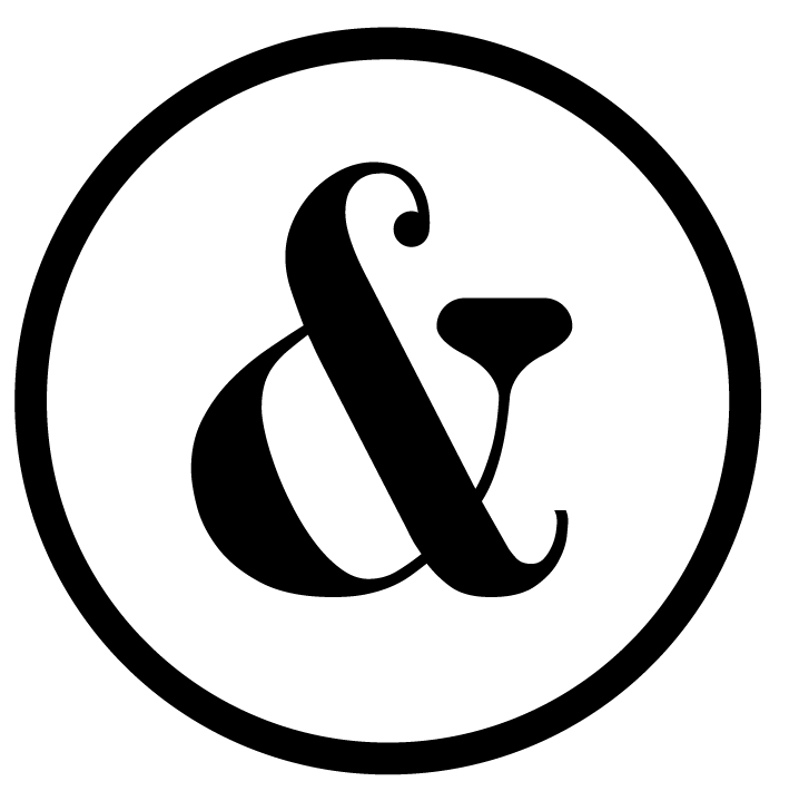 A black and white graphic logo featuring a stylized ampersand symbol inside a circle.
