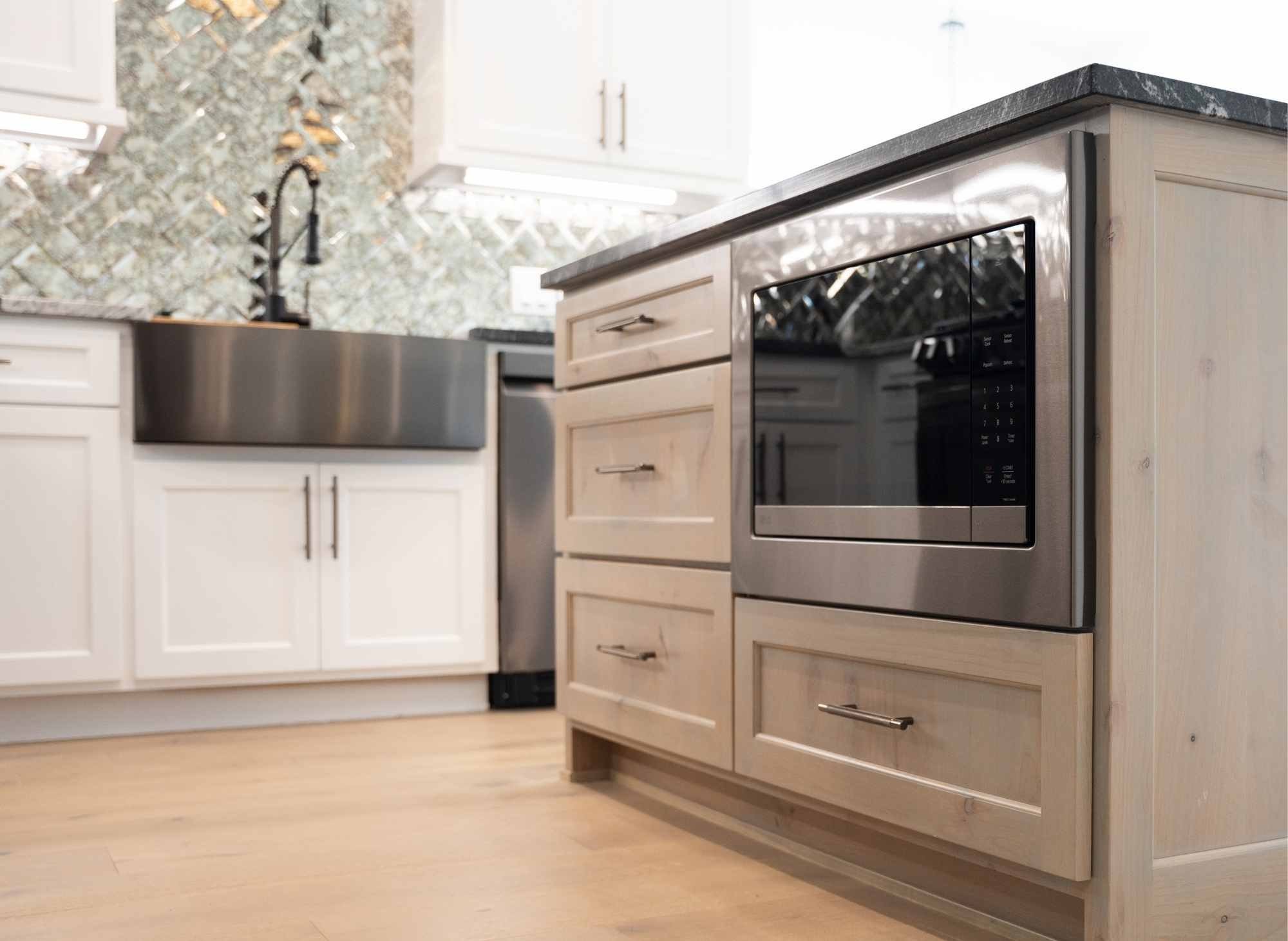 Casita kitchen with Marble countertops, mirrored backsplash, hardwood floors and microwave drawer