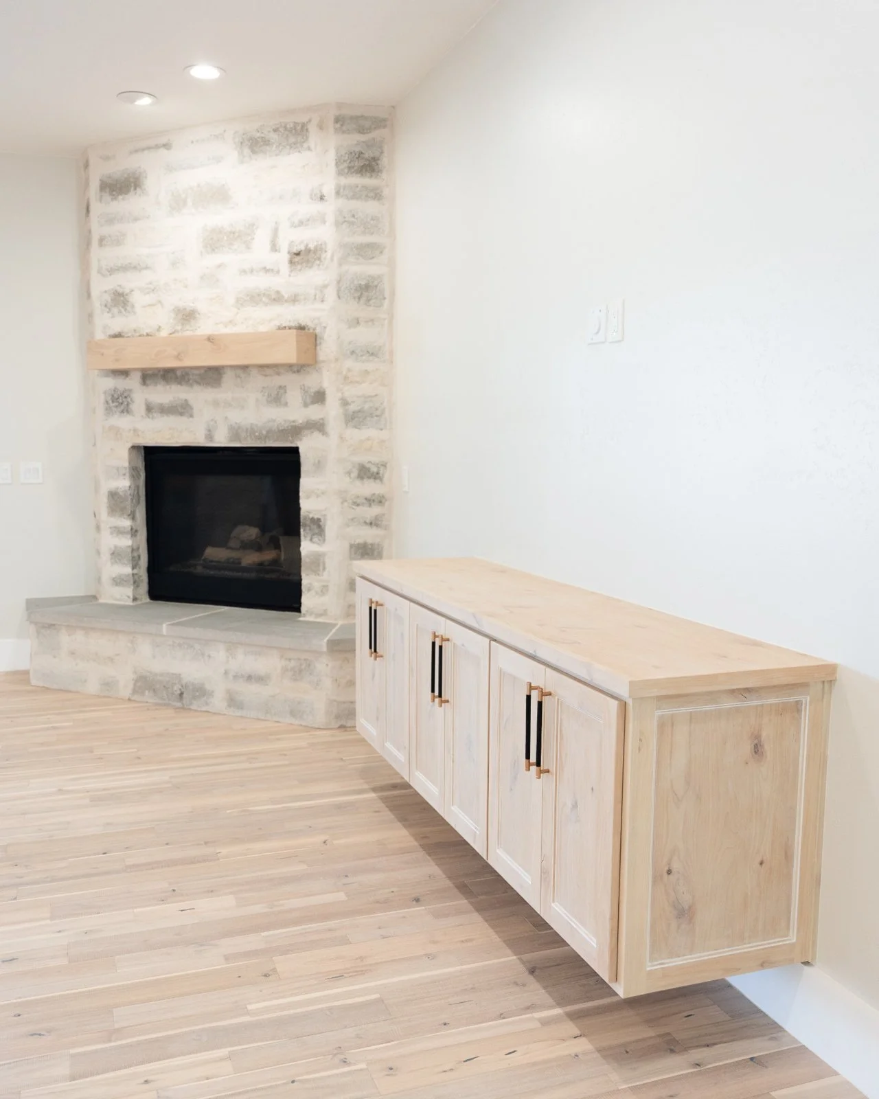 Stone fireplace with custom built floating entertainment center in Central Texas remodel