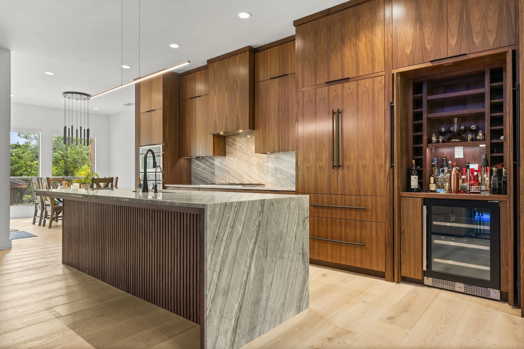 Modern kitchen remodel in Central Texas with walnut cabinetry and quartzite countertops by Atria Design + Build.