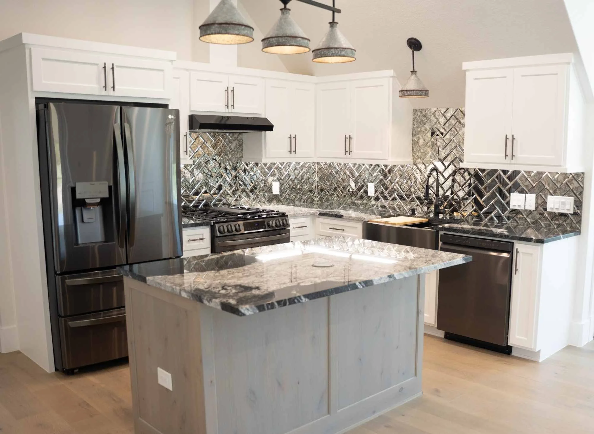 Casita kitchen with Marble countertops, mirrored backsplash, hardwood floors and black gunmetal appliances