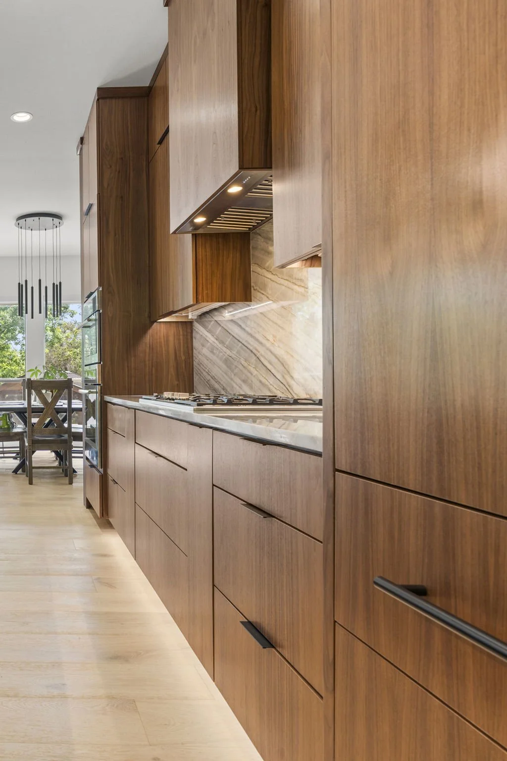 Modern kitchen remodel in Central Texas with walnut cabinetry and quartzite countertops by Atria Design + Build.