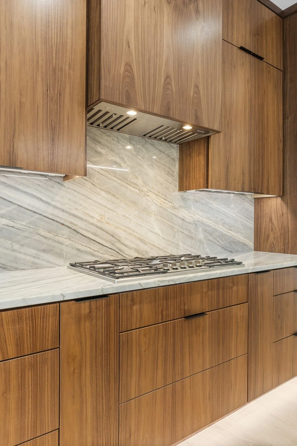 Modern kitchen remodel in Central Texas with walnut cabinetry and quartzite countertops by Atria Design + Build.