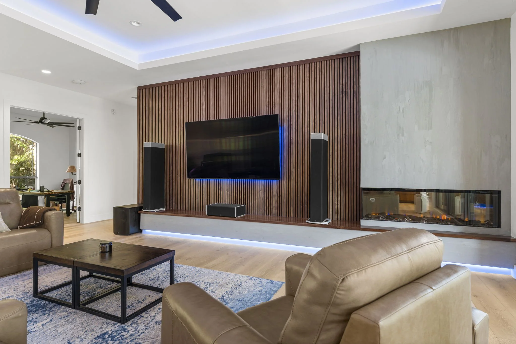 Living room with wood-paneled fireplace and smooth-grain cabinetry in the Madrone Remodel project.
