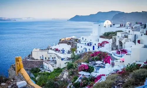 Luxury travel view of Santorini, Greece with whitewashed architecture overlooking the Aegean Sea, featured by Travel With Sabeen.