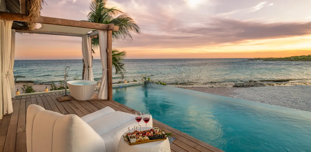 A luxurious beachfront infinity pool with a view of the ocean. - Custom-curated travel management and professional trip planning services in Louisville Kentucky