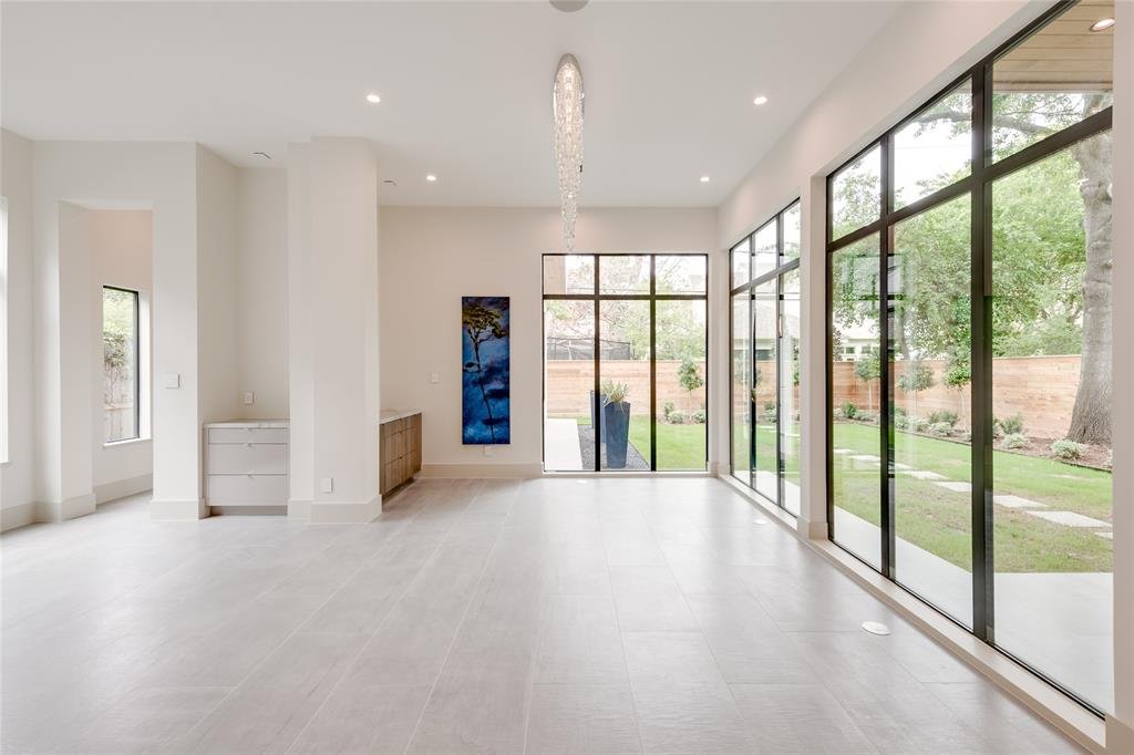 Modern empty living room with large glass sliding doors opening to backyard