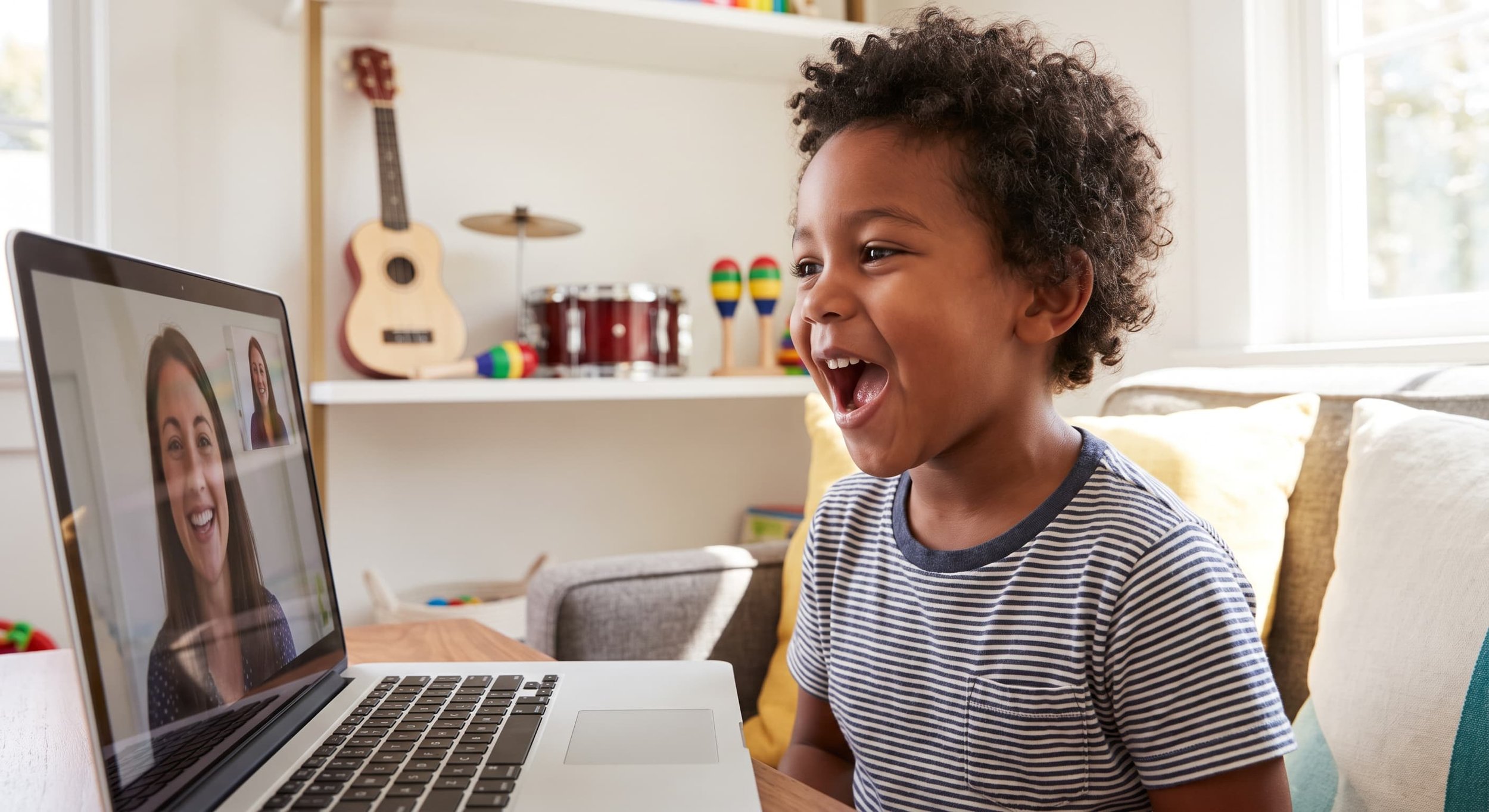 Child smiling during telehealth speech therapy session with licensed speech-language pathologist