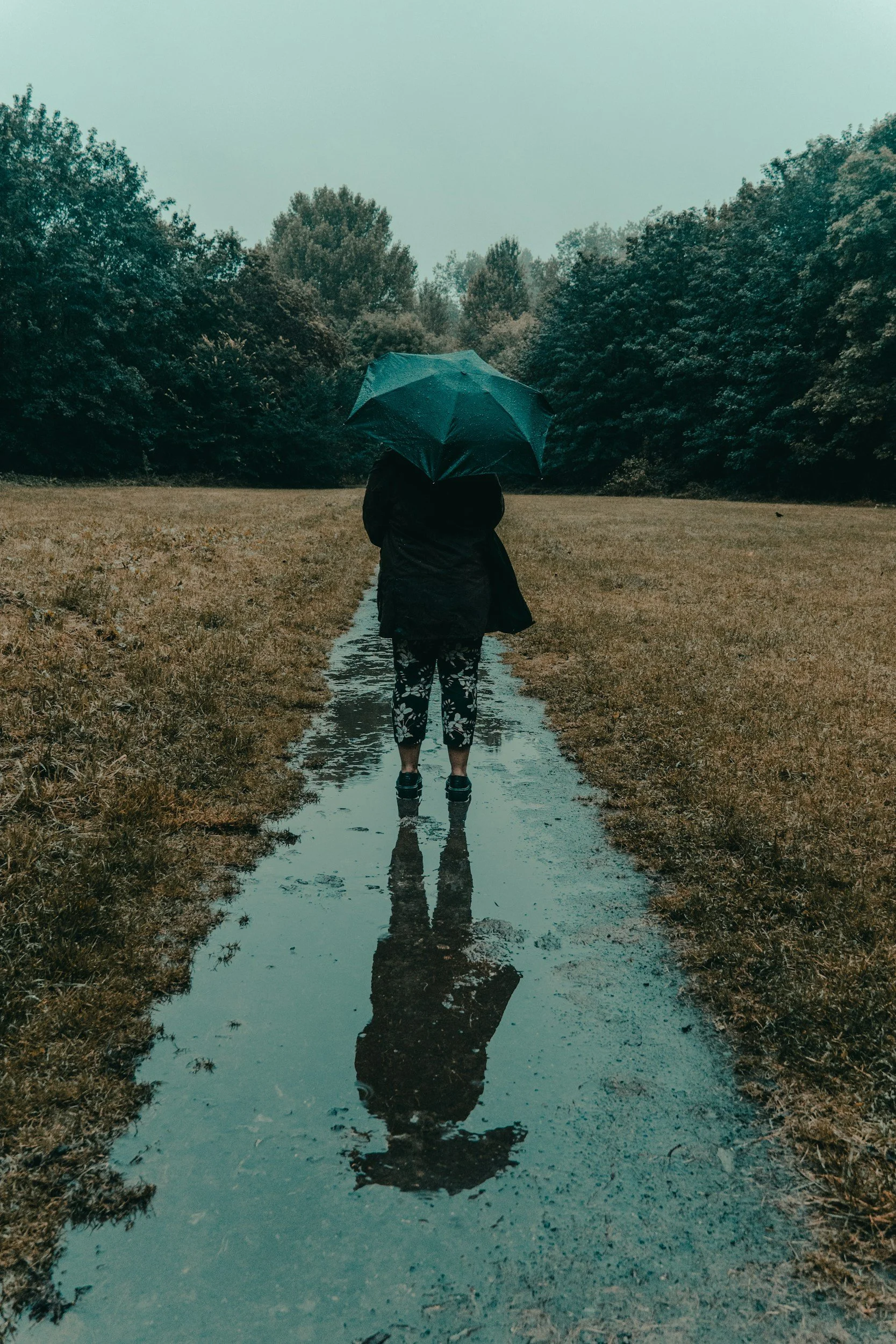 A person holding an umbrella in the rain
