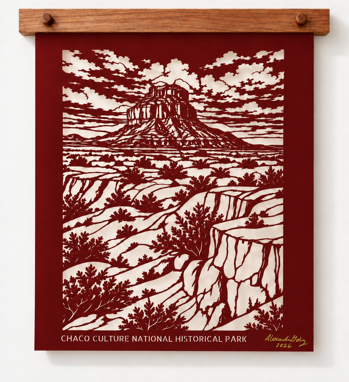Chaco Canyon limited edition cut paper landscape displayed with a wooden  hanger against a neutral wall.