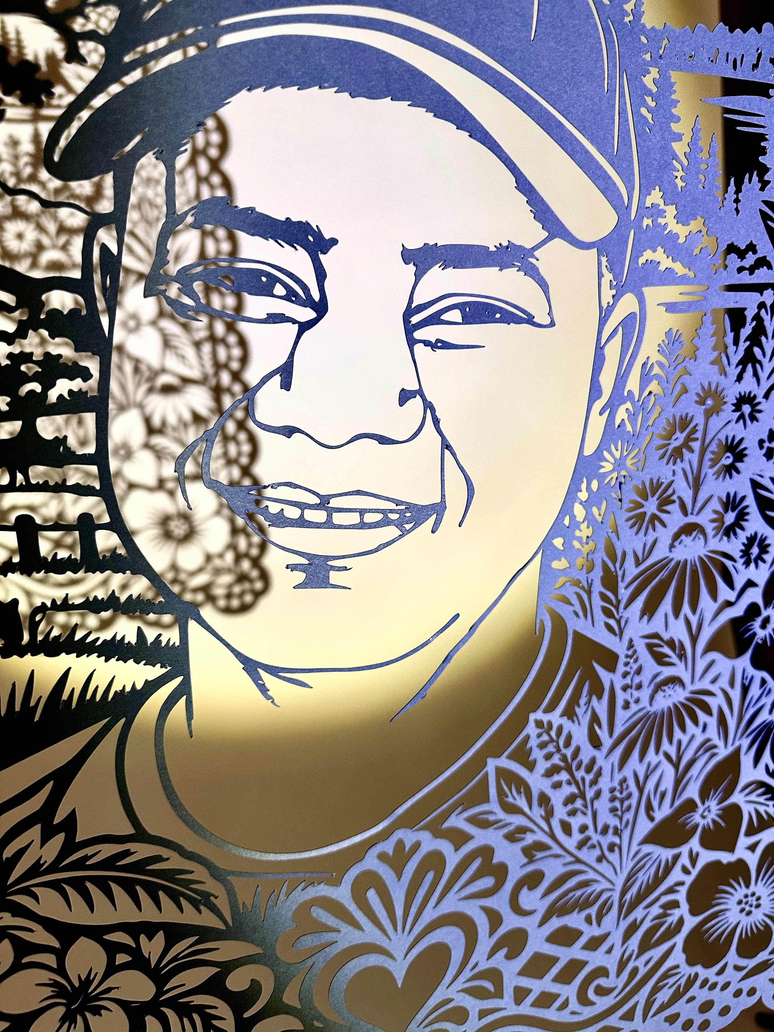 Close up Angled view of Carlos Josué Marchena Marchena’s cut paper portrait casting a shadow on the wall.