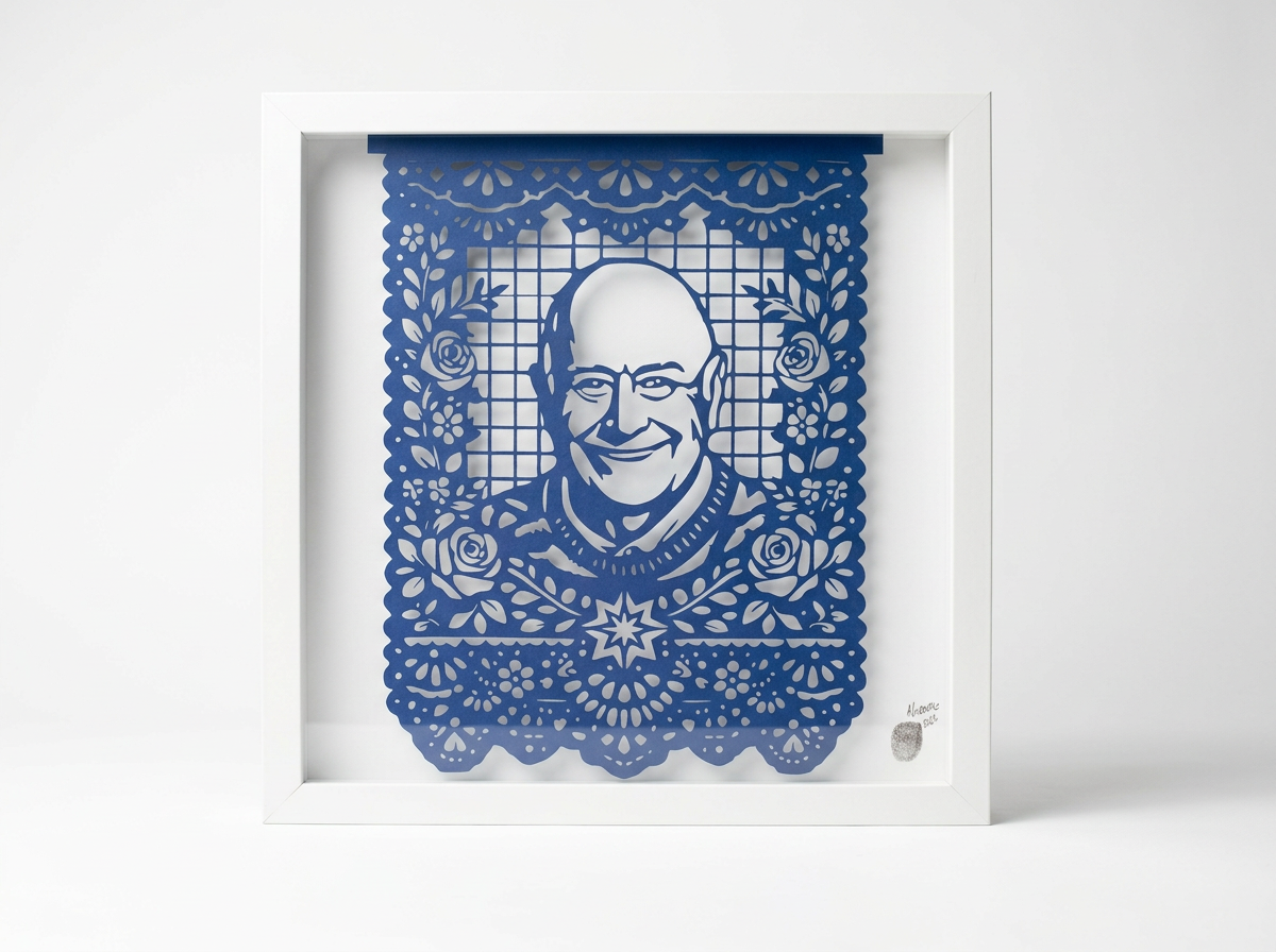 Handcrafted blue papel picado portrait in a white shadow box frame, featuring a personalized cut paper likeness with intricate botanical details.