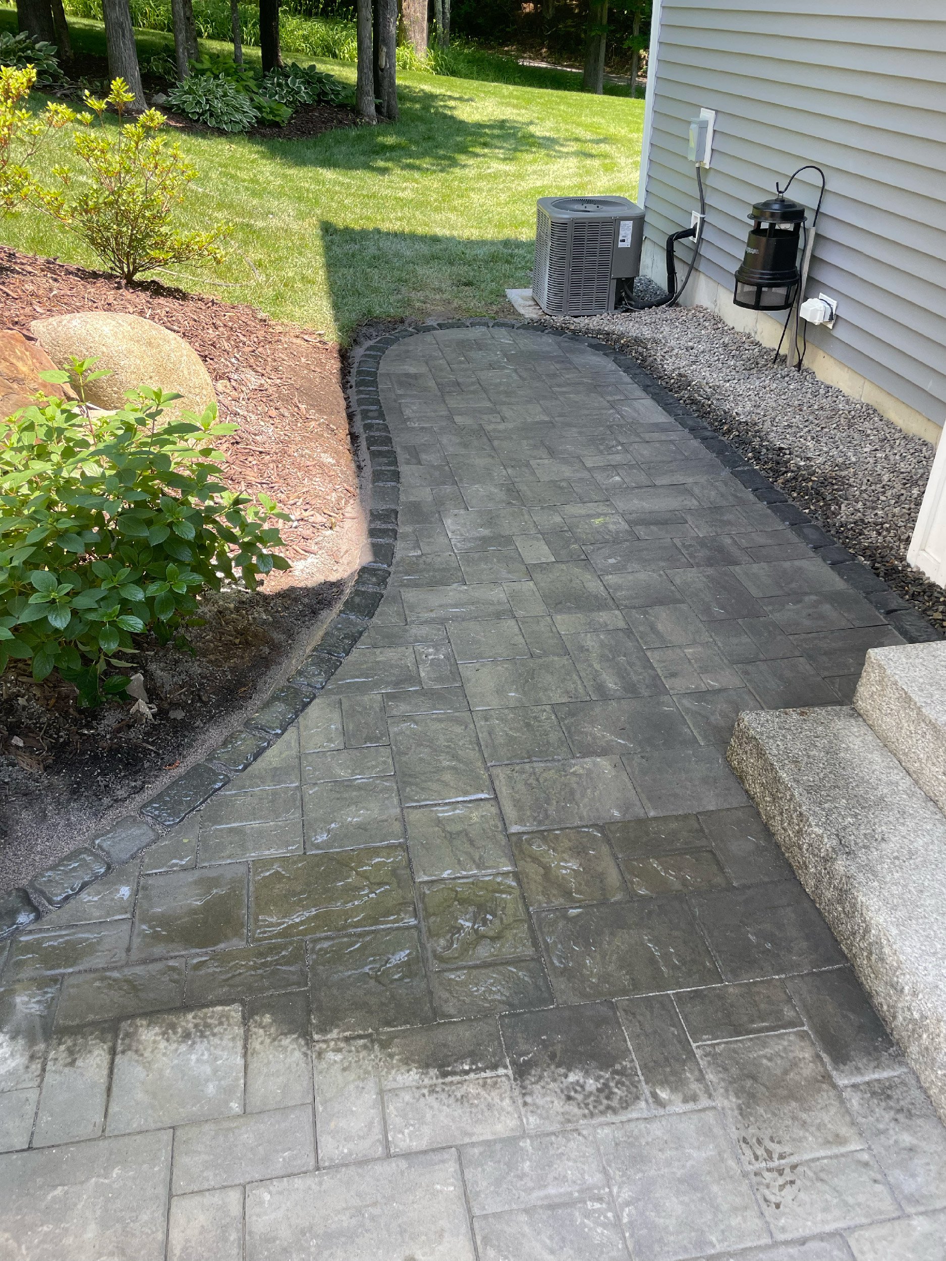 Pathway extension with gray limestone and a charcoal border built by The Englishmen Masonry