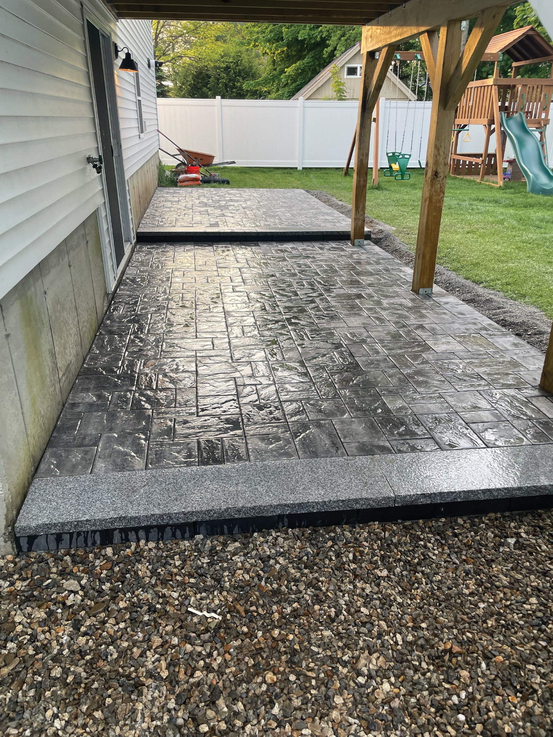 Large two-tier limestone backyard patio with granite steps built by The Englishmen Masonry in Portsmouth, NH