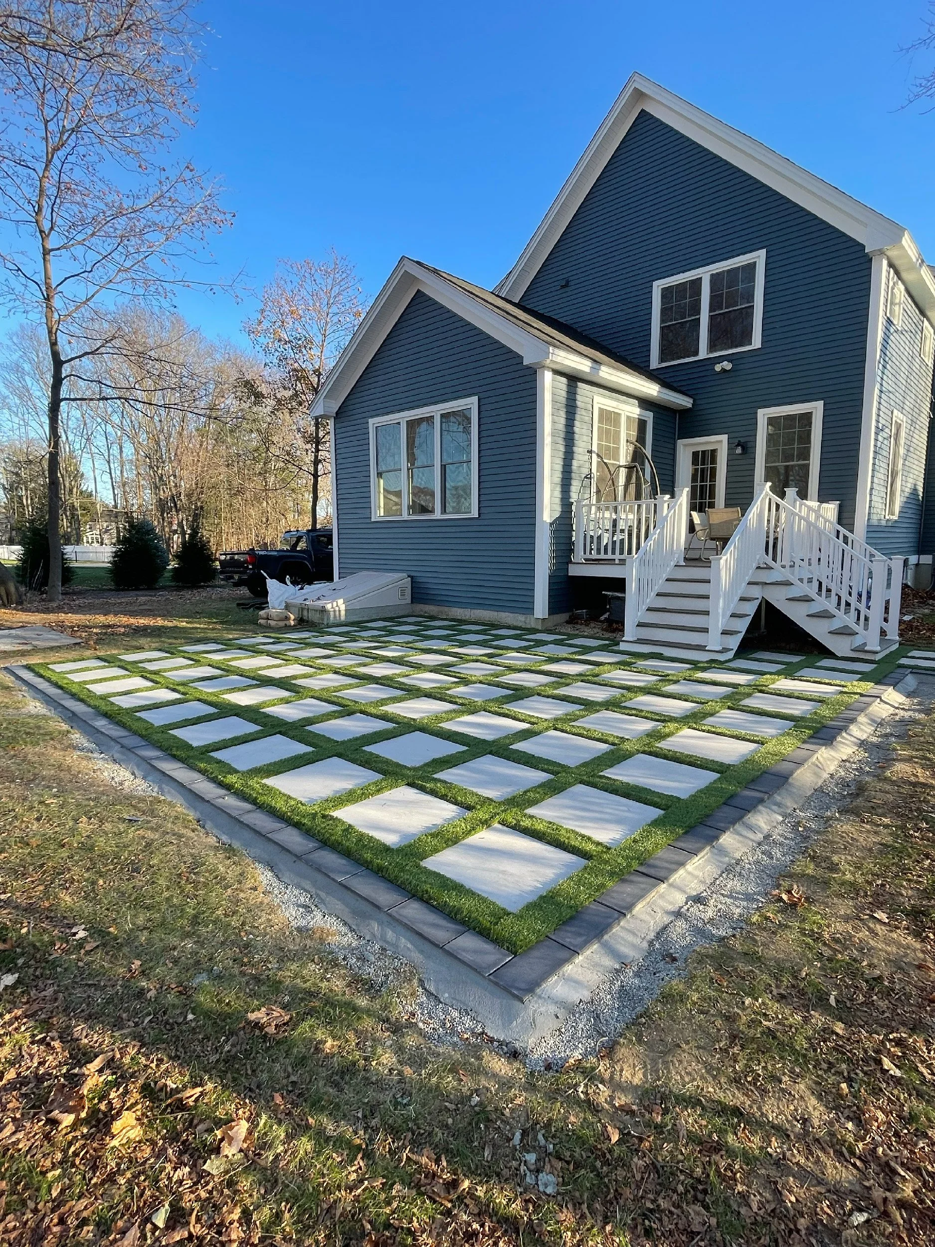 Modern patio built in Exeter, NH with techo-block pavers and golden vale turf, hardscaping by The Englishmen Masonry