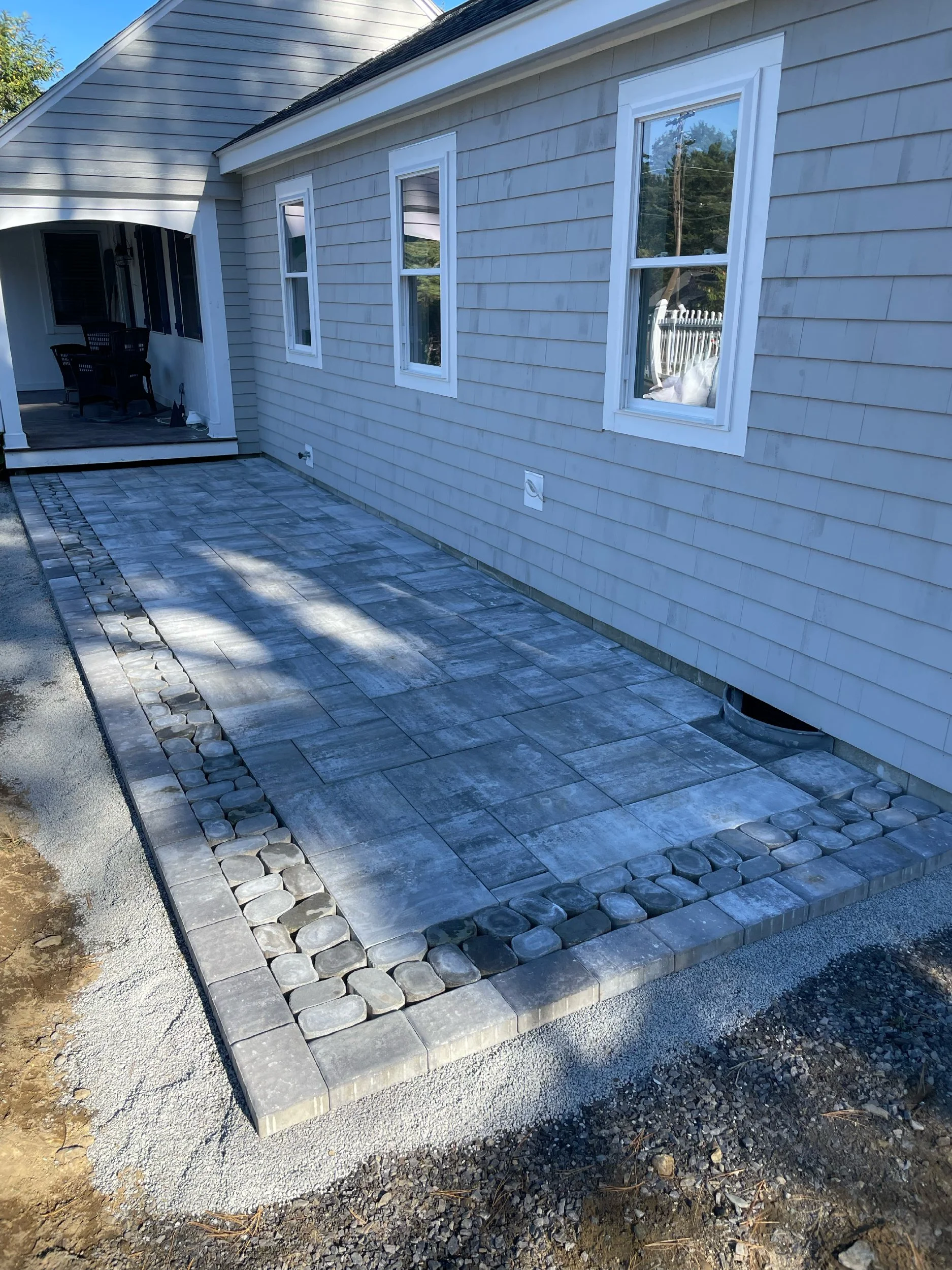 Scarborough, Maine cottage with a three-piece stone front patio hardscape built by The Englishmen Masonry