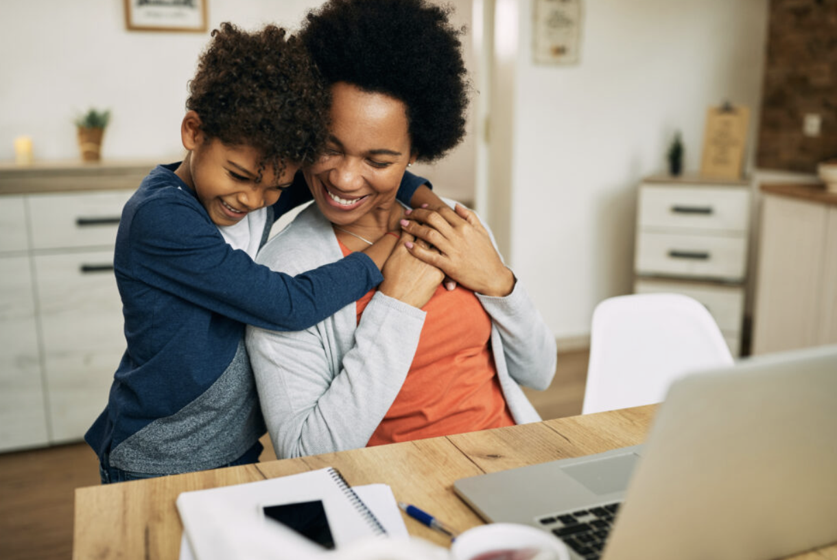 working parent balancing family and career while embracing child at home office workspace
