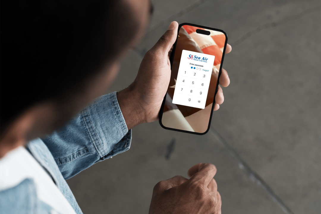 Person holding a phone. On the phone screen is the Sea Air logo.