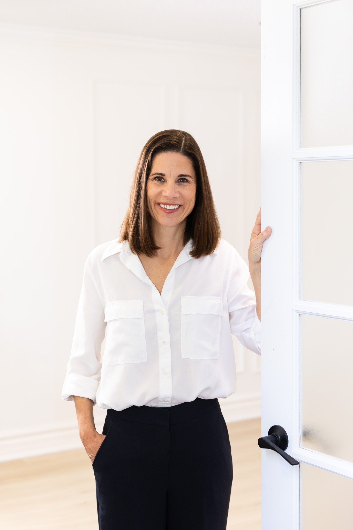 Tanya Melykuty standing in a doorway, representing connection and access to virtual therapy in Ontario for stress, caregiving, and life transitions.