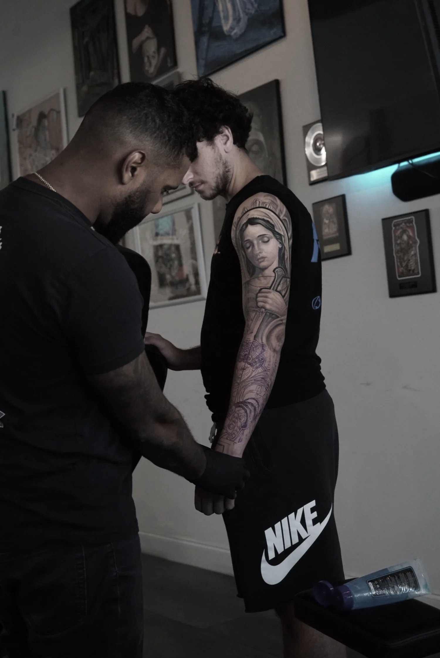 Black and grey realism tattoo of Virgin Mary woman holding a sword Charlotte 