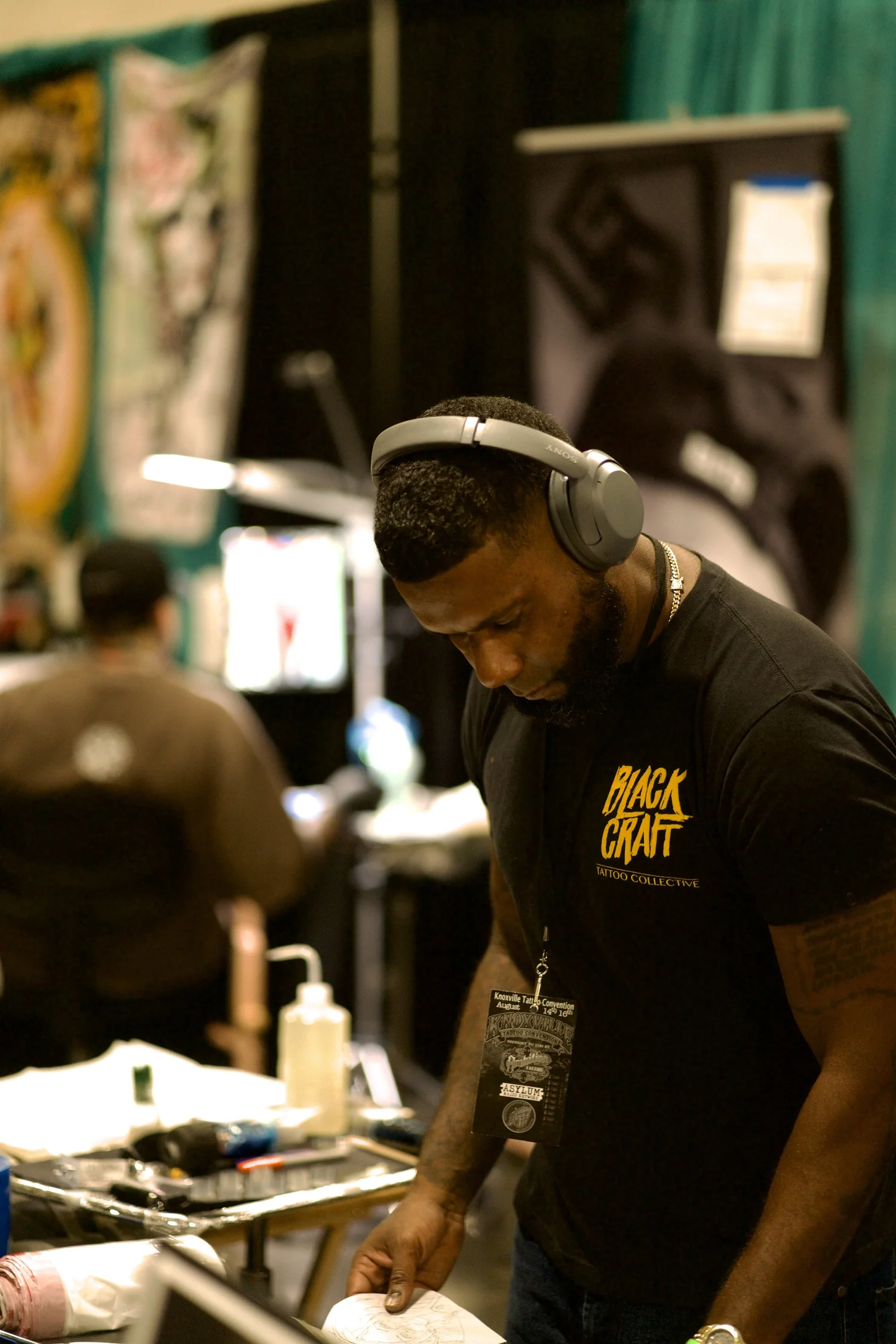 Tattoo artist Luis D working at a tattoo convention booth
