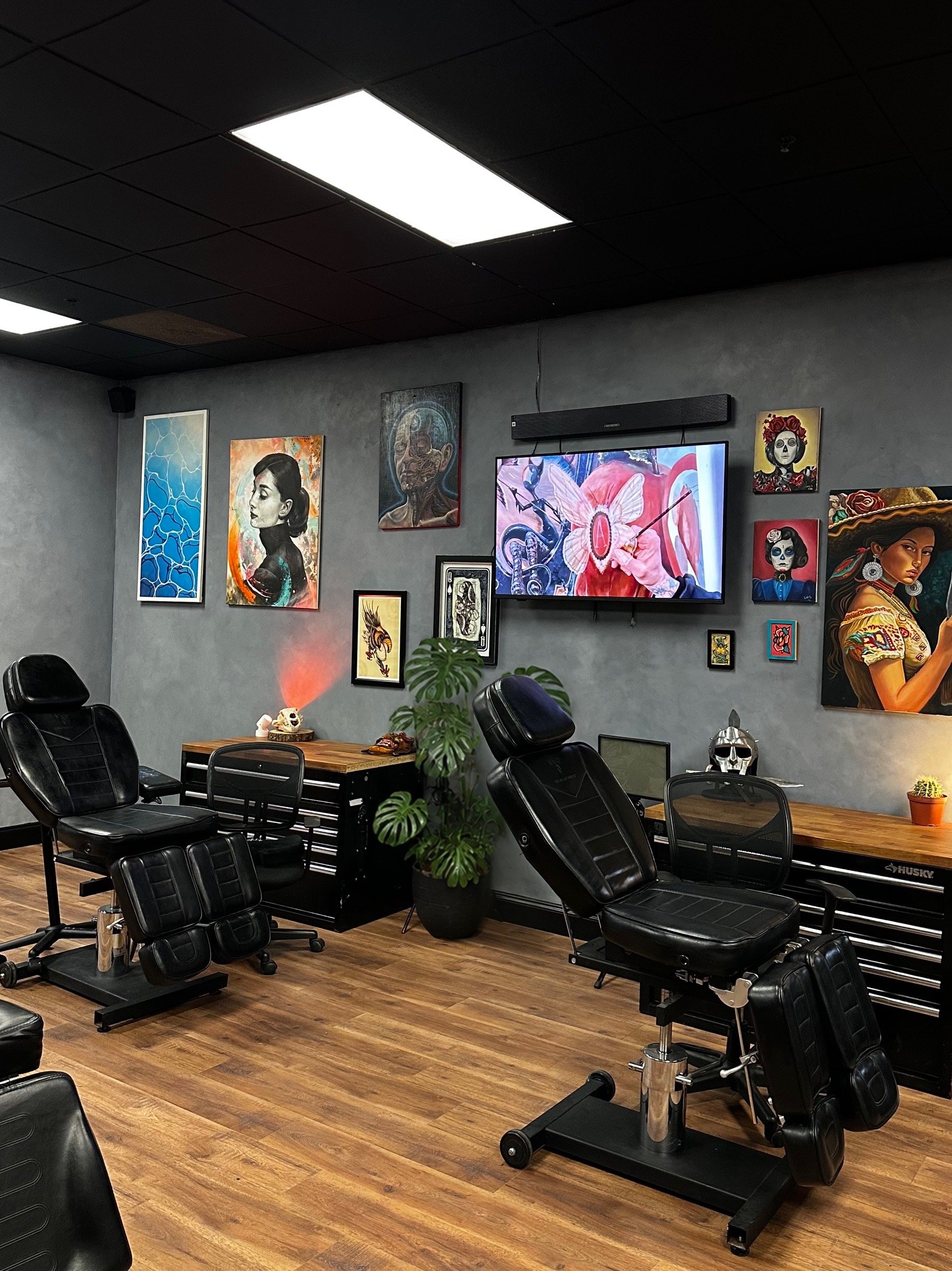 Black Craft Tattoo Collective studio interior in Charlotte with artwork, seating and modern lighting.