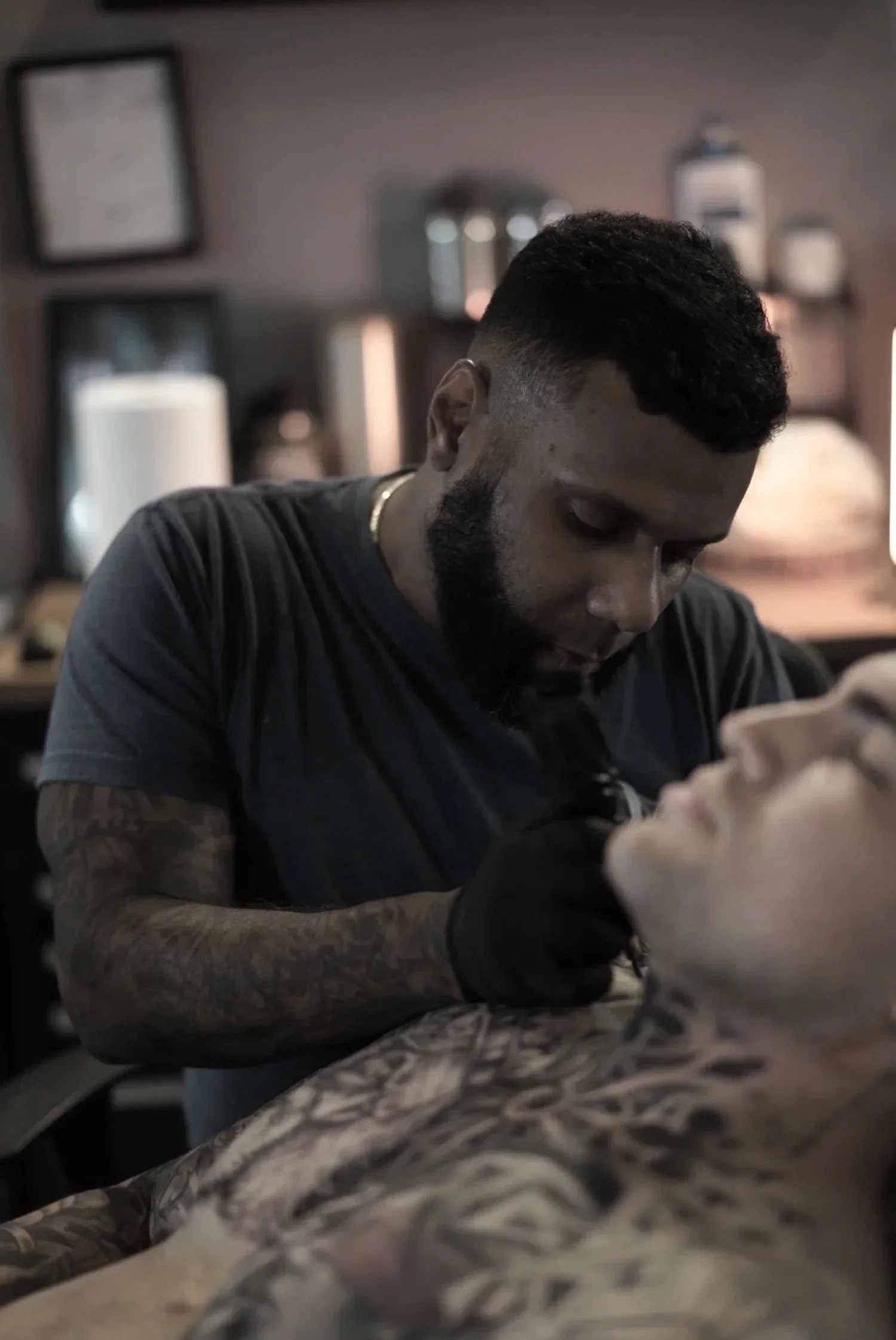 Tattoo artist Luis D’Art tattooing a client in a Charlotte studio