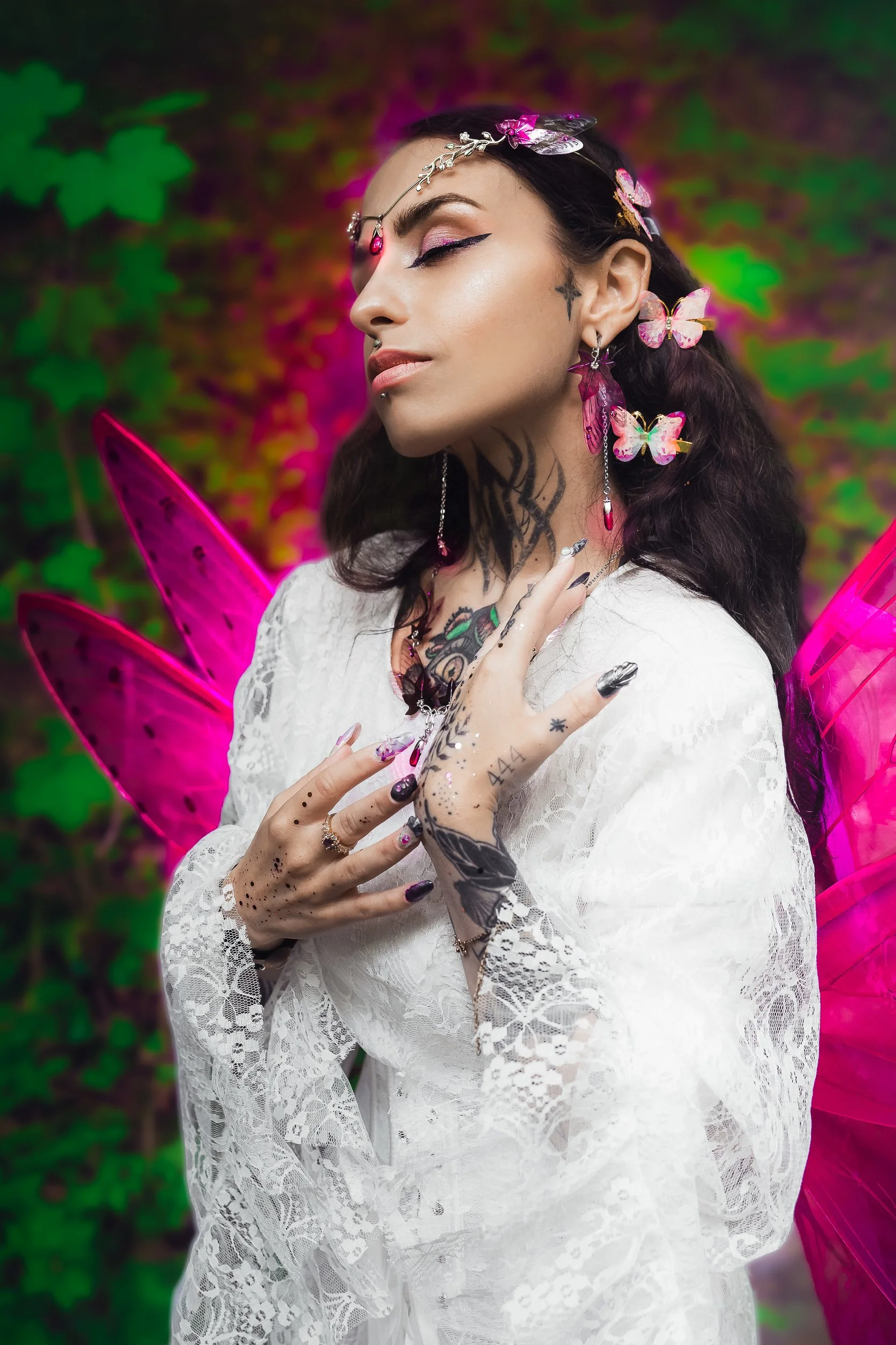 Fée aux ailes roses, portant une robe blanche en dentelle, avec des tatouages, des bijoux roses et des ailes de papillon roses, dans un décor coloré avec des feuilles vertes.