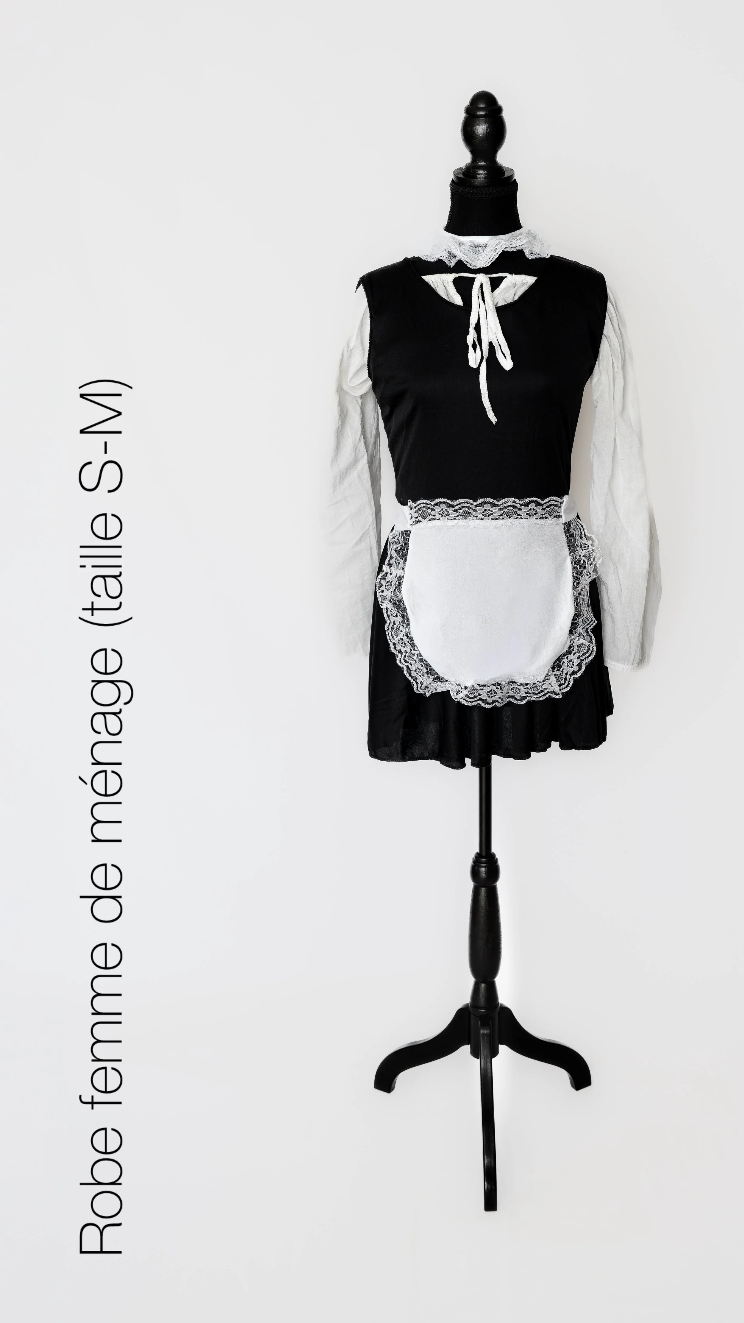 Vitrine avec une robe de femme faite de memoire (taille S-M) inspirée d'une robe de maid ou de serveuse, style traditionnel avec un tablier en dentelle blanche et un crochet blanc, manches longues et un col lacé.