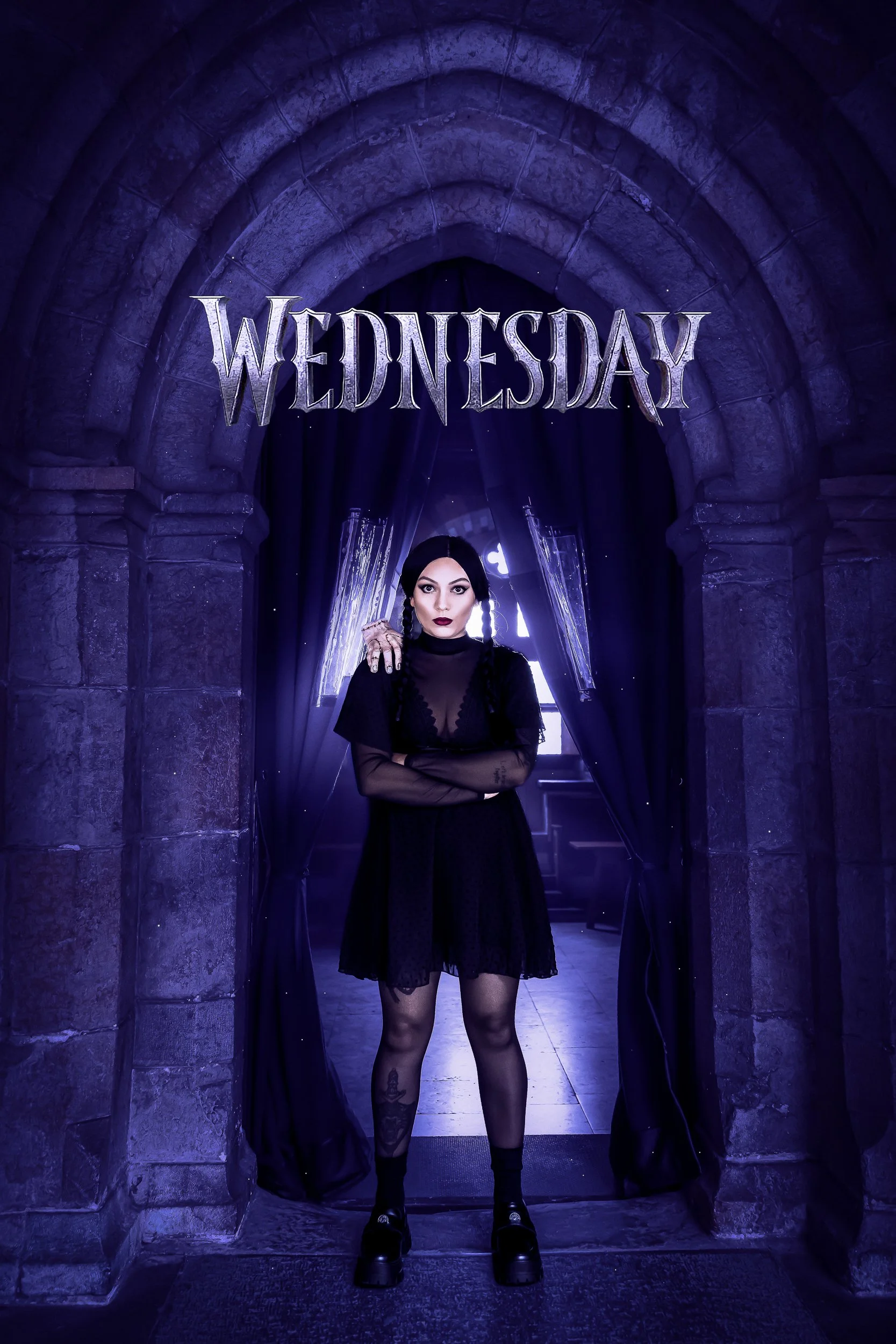 Une jeune femme dans une robe noire en haut d'un monument en pierre, avec des arches et des rideaux noirs, sous un éclairage violet, et la semaine affichée en haut, mardi.