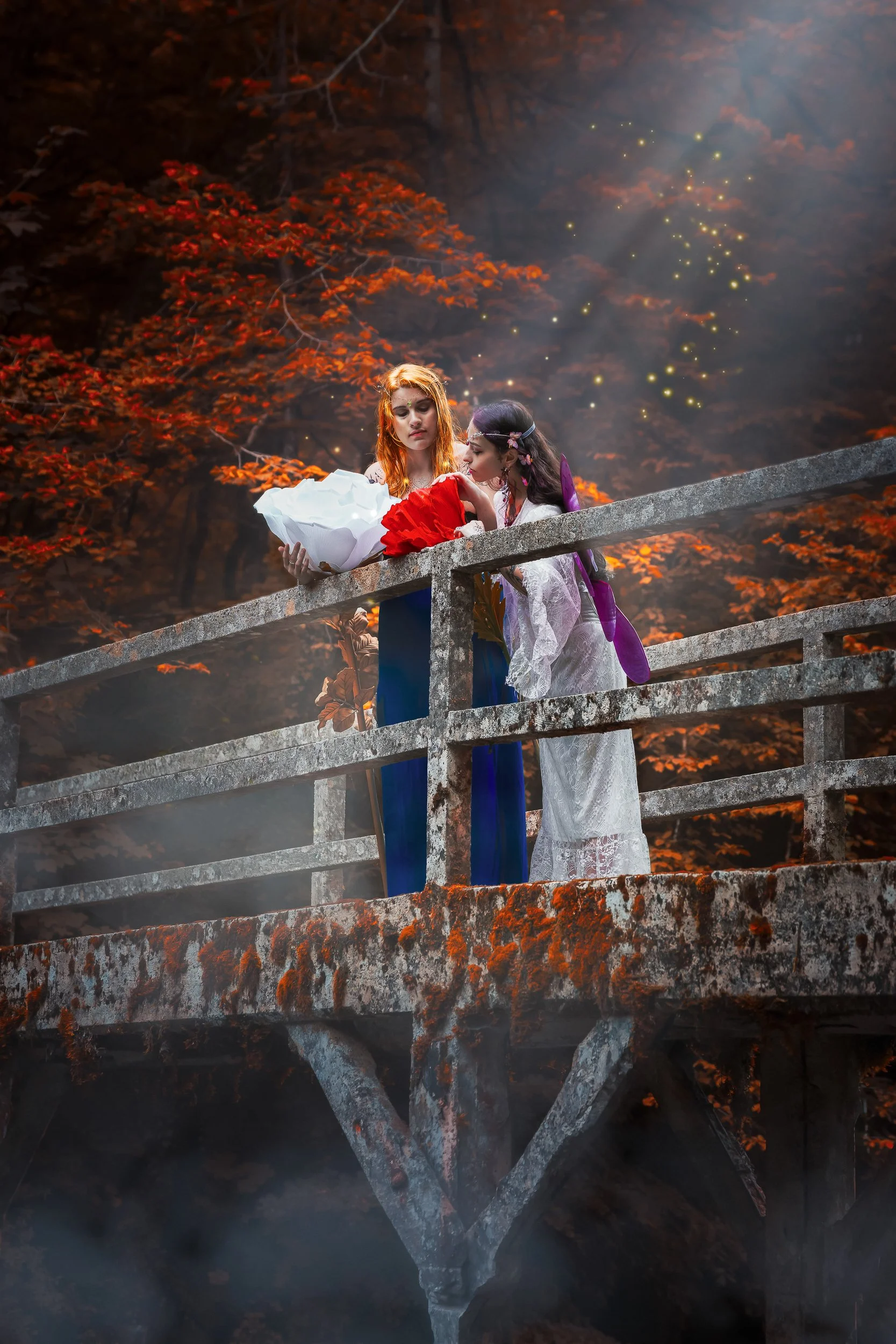 Deux femmes en costume médiéval ou fantastique sur un pont en pierre dans une forêt aux feuilles d'automne, avec des effets de lumière et des étincelles magiques dans l'air.