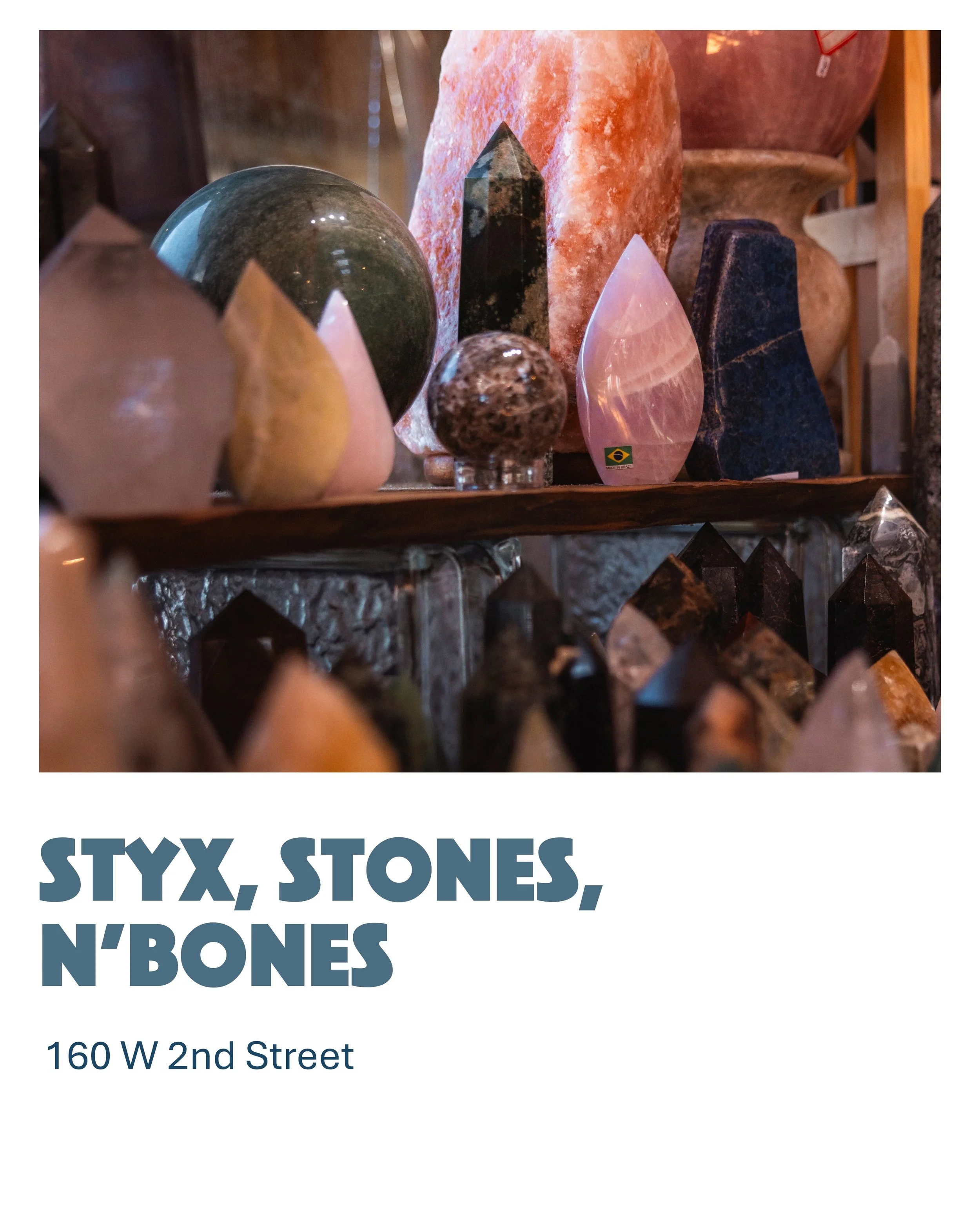 A display of various decorative stones and crystals of different shapes, sizes, and colors on shelves in a shop.