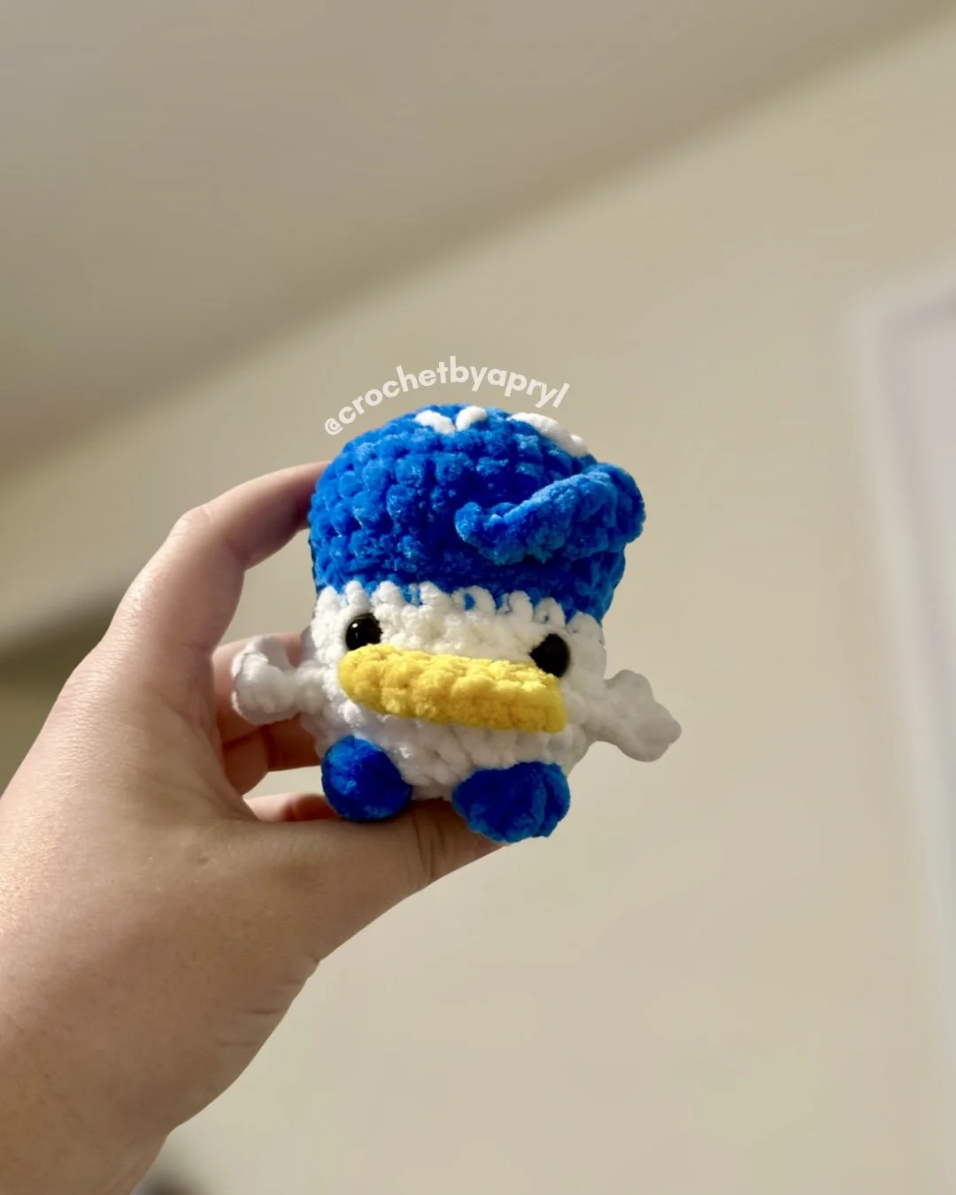 a small crochet plush of a chubby Quaxley