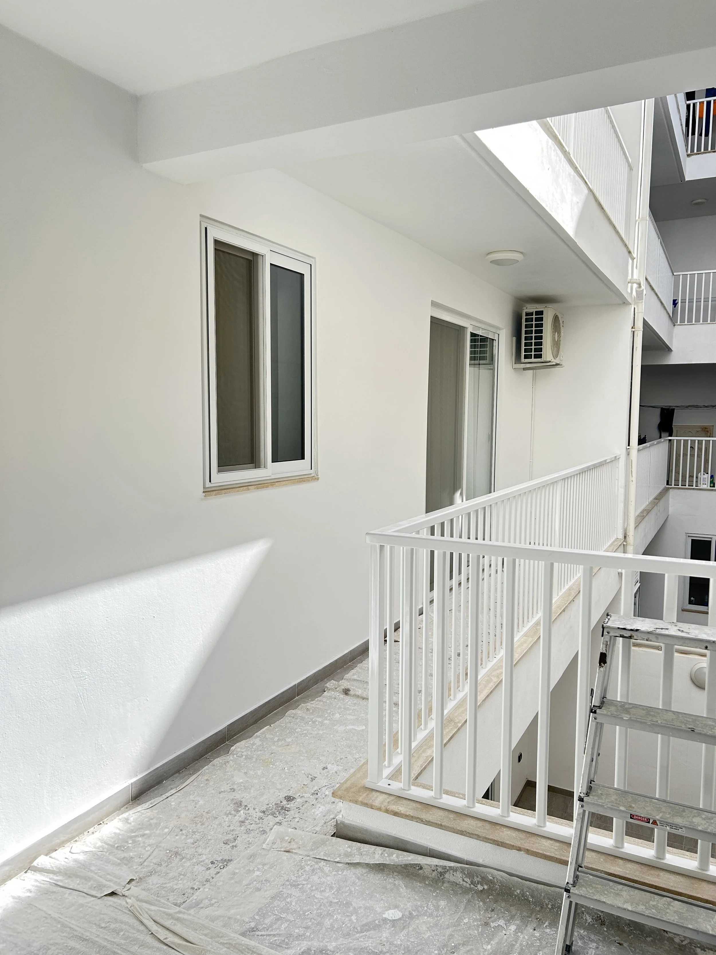 Back balcony in Malta painted in a clean white exterior finish.
