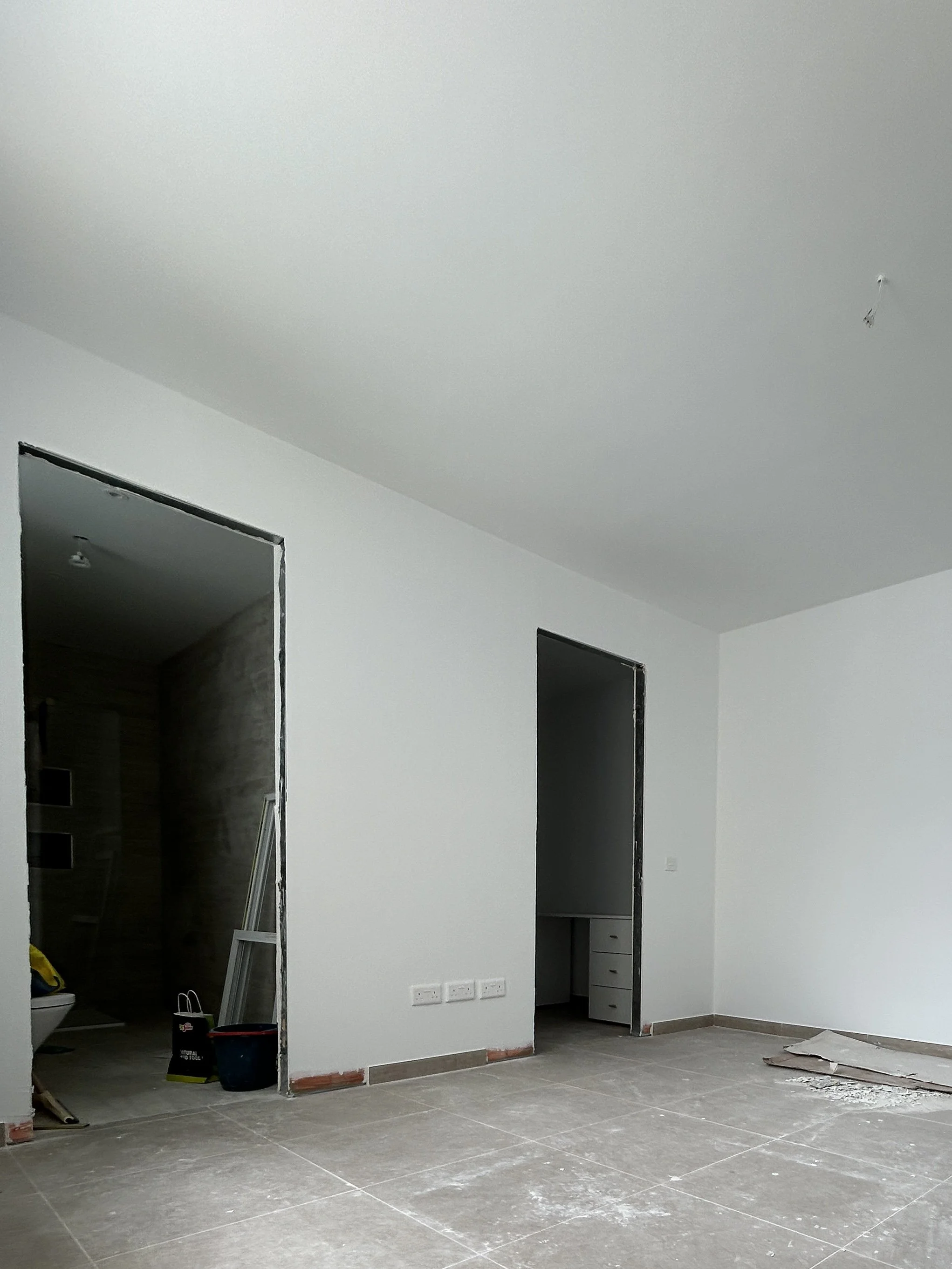 Gypsum partition wall dividing a large bedroom into multiple spaces.