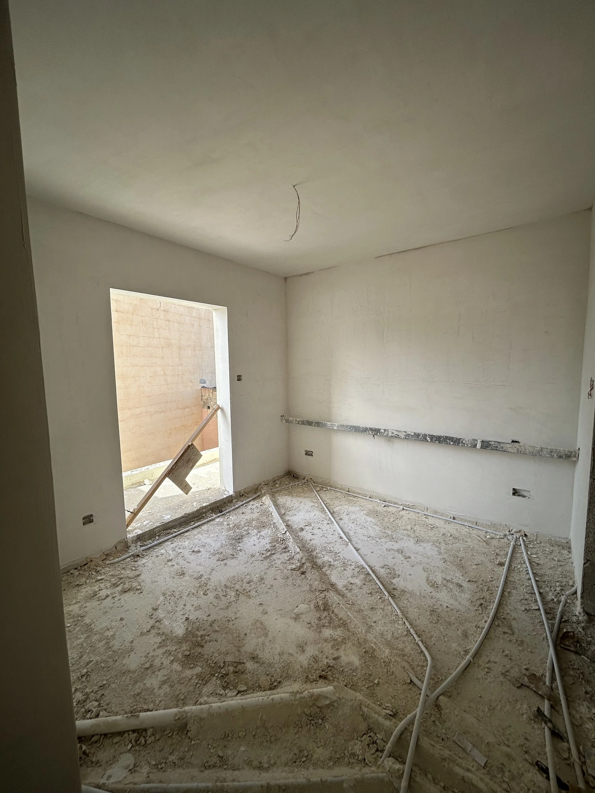 Smooth interior plaster finish in a bedroom creating clean and even walls in a Maltese home