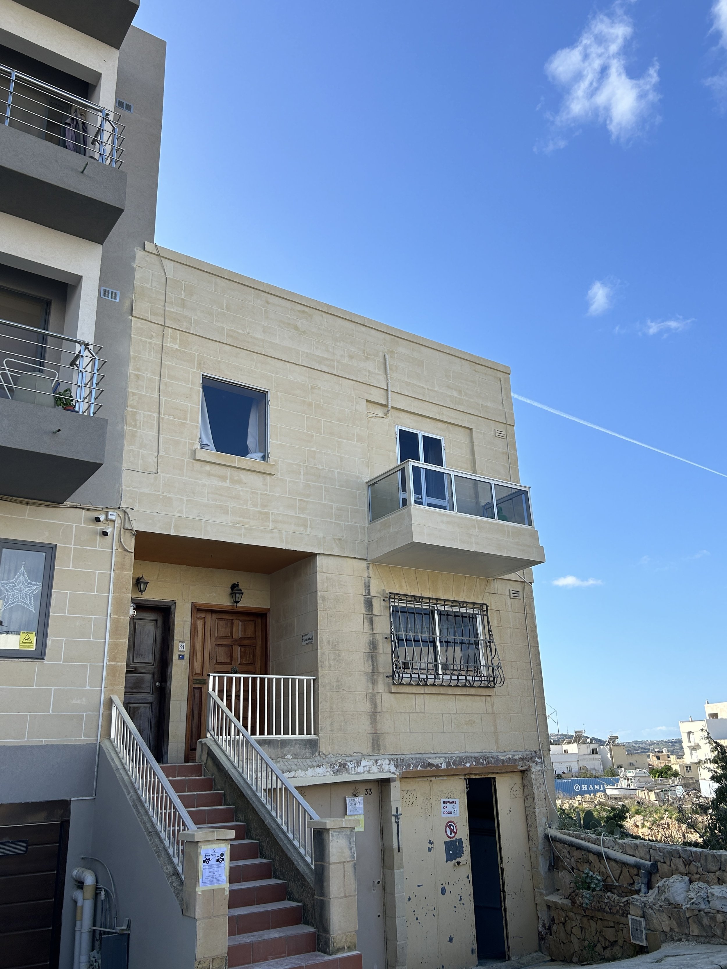 Renovated traditional Maltese fuq il-fil facade at second-floor level.