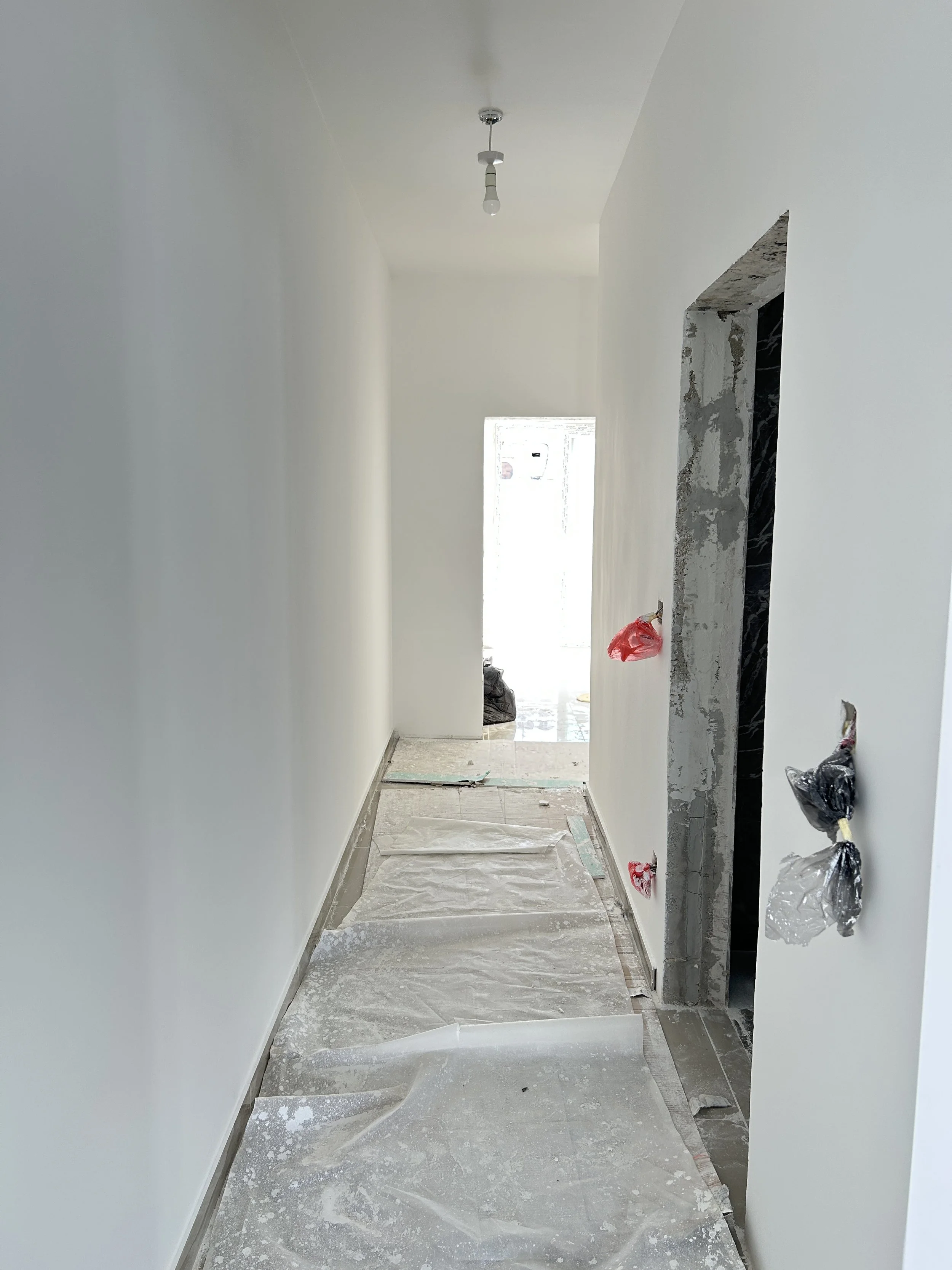 Apartment corridor in Malta painted in a bright white finish.