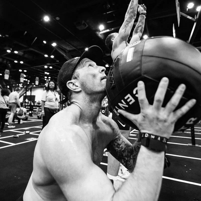 Competitor at Hyrox doing wall balls in the squat position