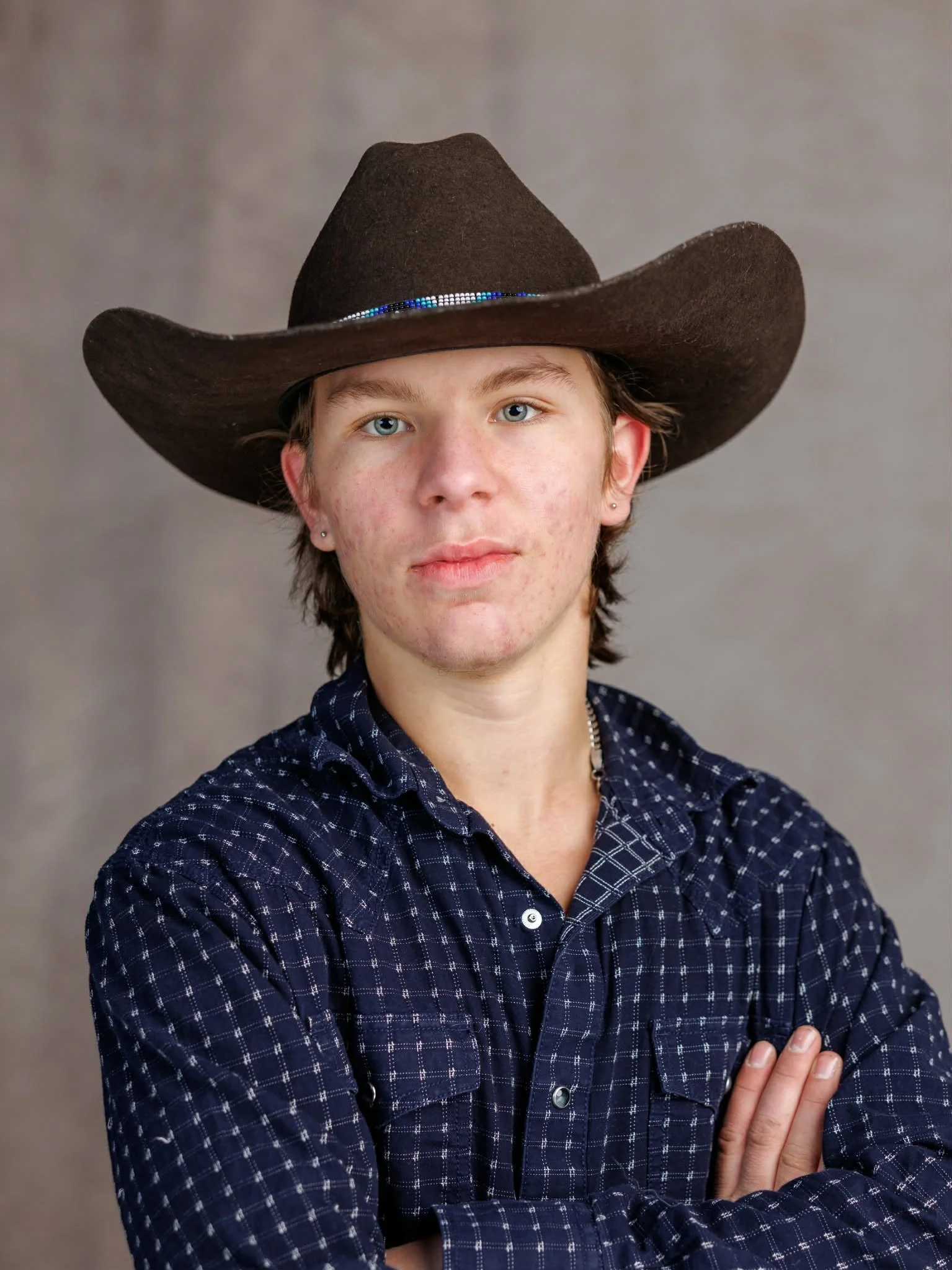 A young man in blue shirt and cowboy hat. Rodeo bull rider