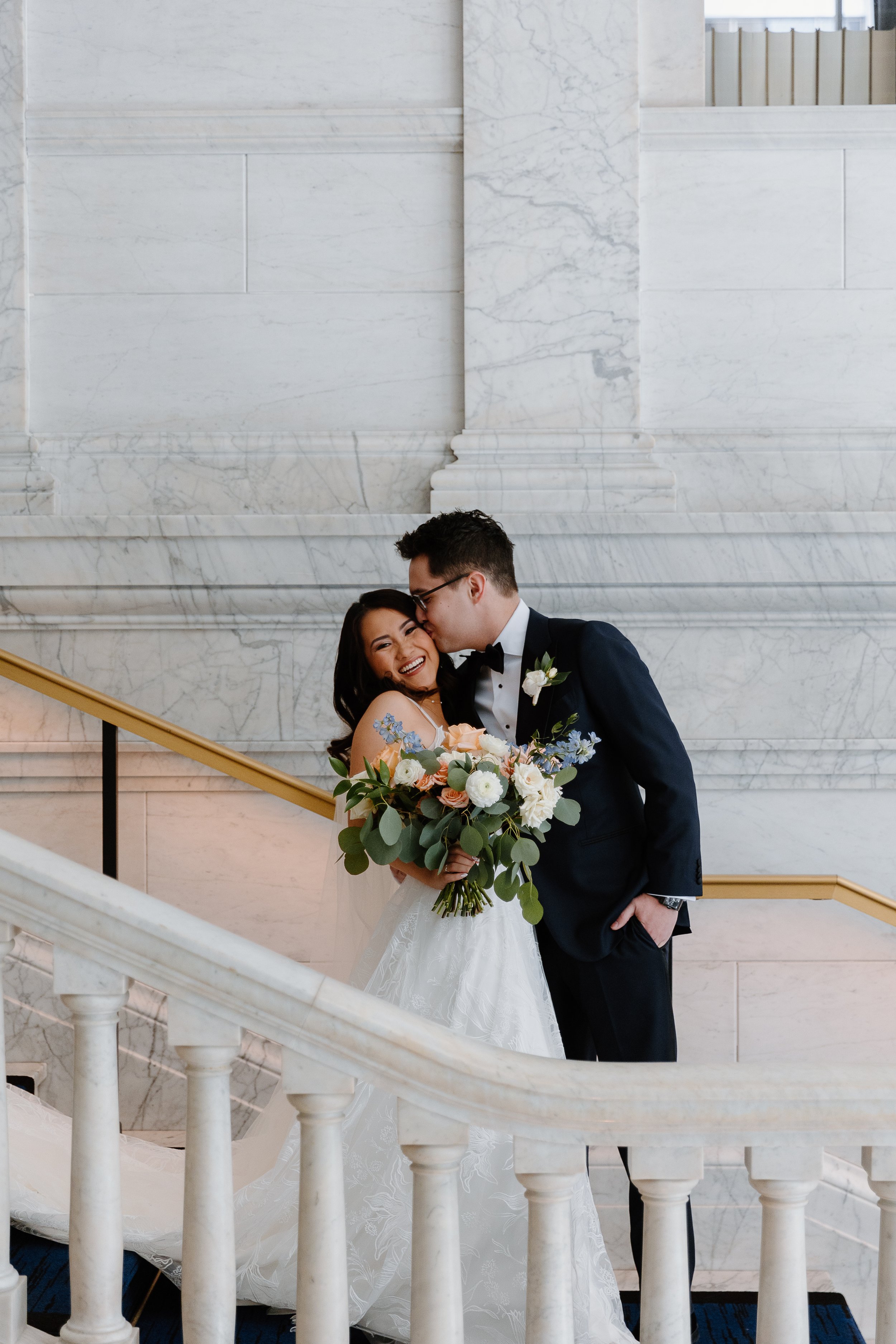 Bride and groom kissing on a staircase